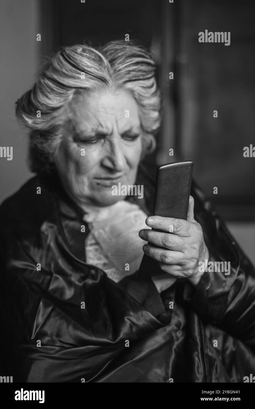 Die autoritative Richterin runzt die Stirn, während sie die Nachrichten auf ihrem Smartphone liest. Sie trägt ihre professionelle Kleidung und scheint sich zu nähern Stockfoto