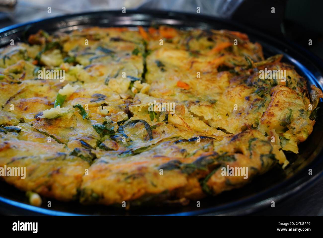 Fischpfannkuchen ist ein traditionelles koreanisches Gericht, das aus Meeresfrüchten und grünen Zwiebeln zubereitet wird. Stockfoto