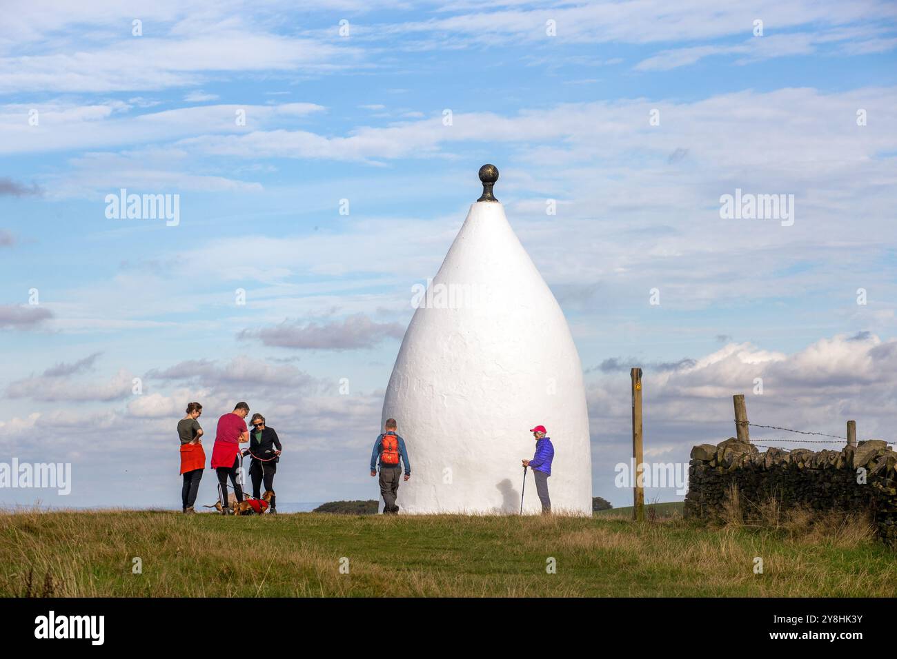 Wanderer und Rucksacktouristen in White Nancy, einem von Menschenhand geschaffenen Wahrzeichen auf dem Gritstone Trail auf der Spitze des Kerridge Hill mit Blick auf Bollington, Cheshire Stockfoto