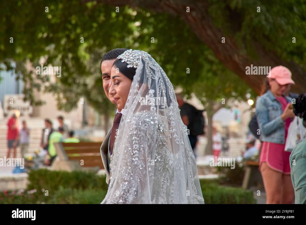 Buchara, Usbekistan; 19. September 2024: Ein romantischer Moment, in dem Jungvermählte durch die alten Straßen von Buchara, Usbekistan, schlendern. Stockfoto