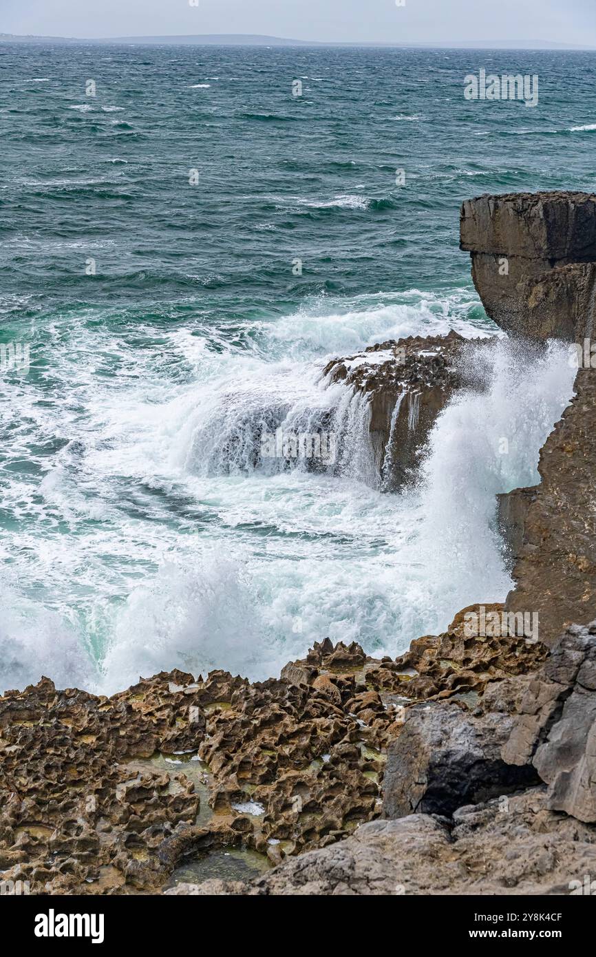 Wellen des Atlantiks stürzen gegen die Ballyryan Cliffs Stockfoto