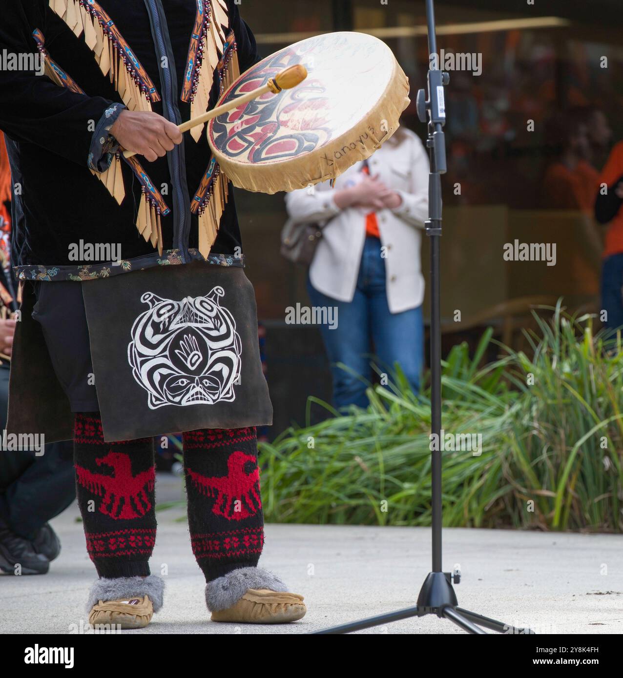Eine Tänzerin in Insignien aus der Squamish Nation in British Columbia, Kanada, tritt mit einer Trommel bei einer Truth and Reconciliation Veranstaltung auf. Stockfoto