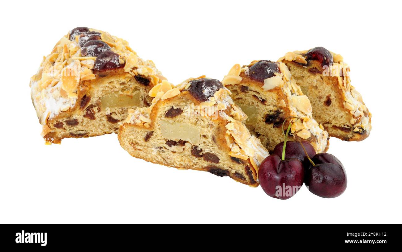 Kirsch- und Mandelstollen-Obstkuchen gefüllt mit Rosinen und Marzipane und dekoriert mit Glaskirschen und Mandelblättchen isoliert auf weißem Hintergrund Stockfoto