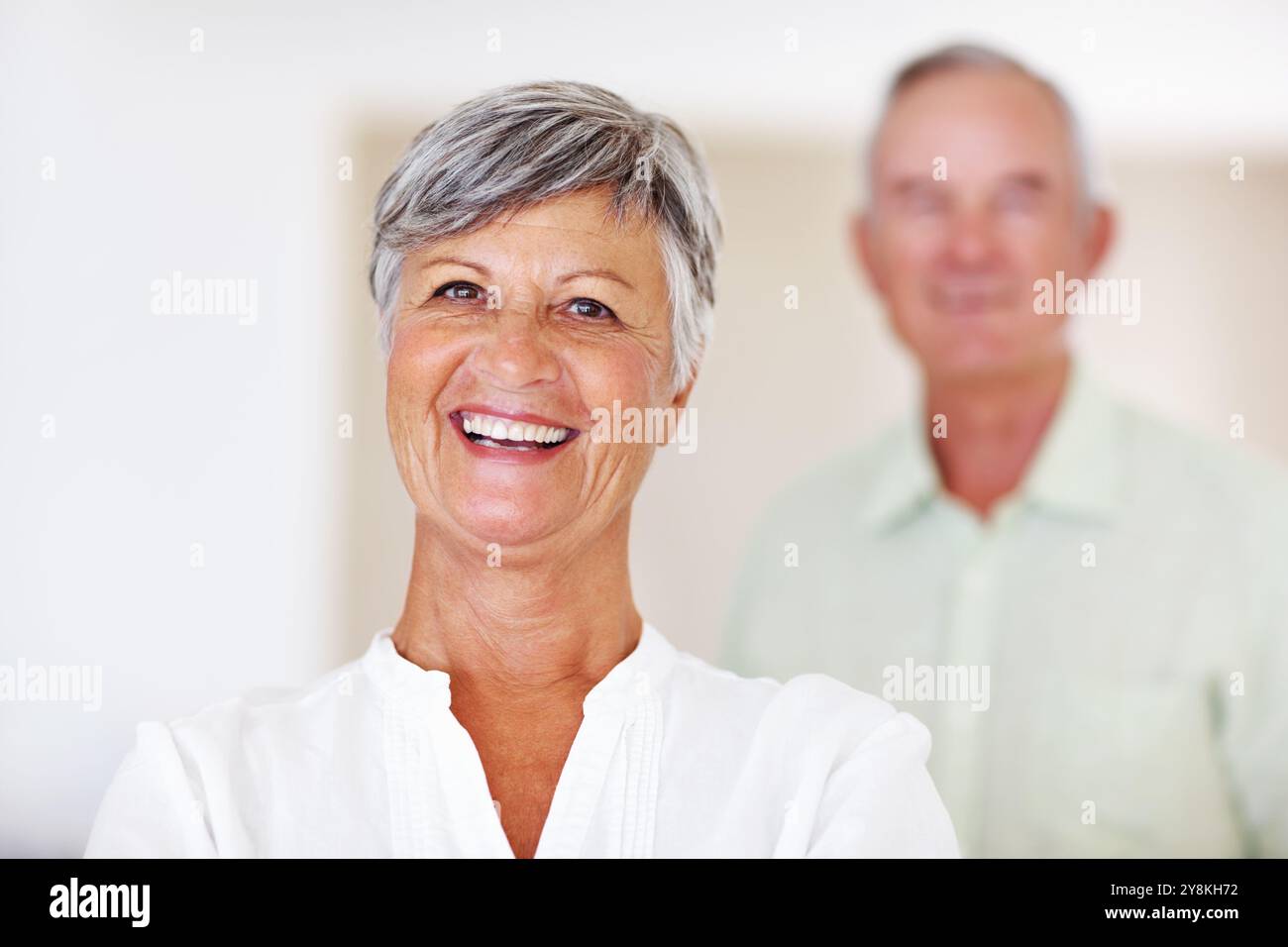 Heim, Seniorin und Lachen im Porträt für Ruhestand, Trost und Glück mit positiver Einstellung. Älteres Paar, weibliche Person und alter Mann in Stockfoto