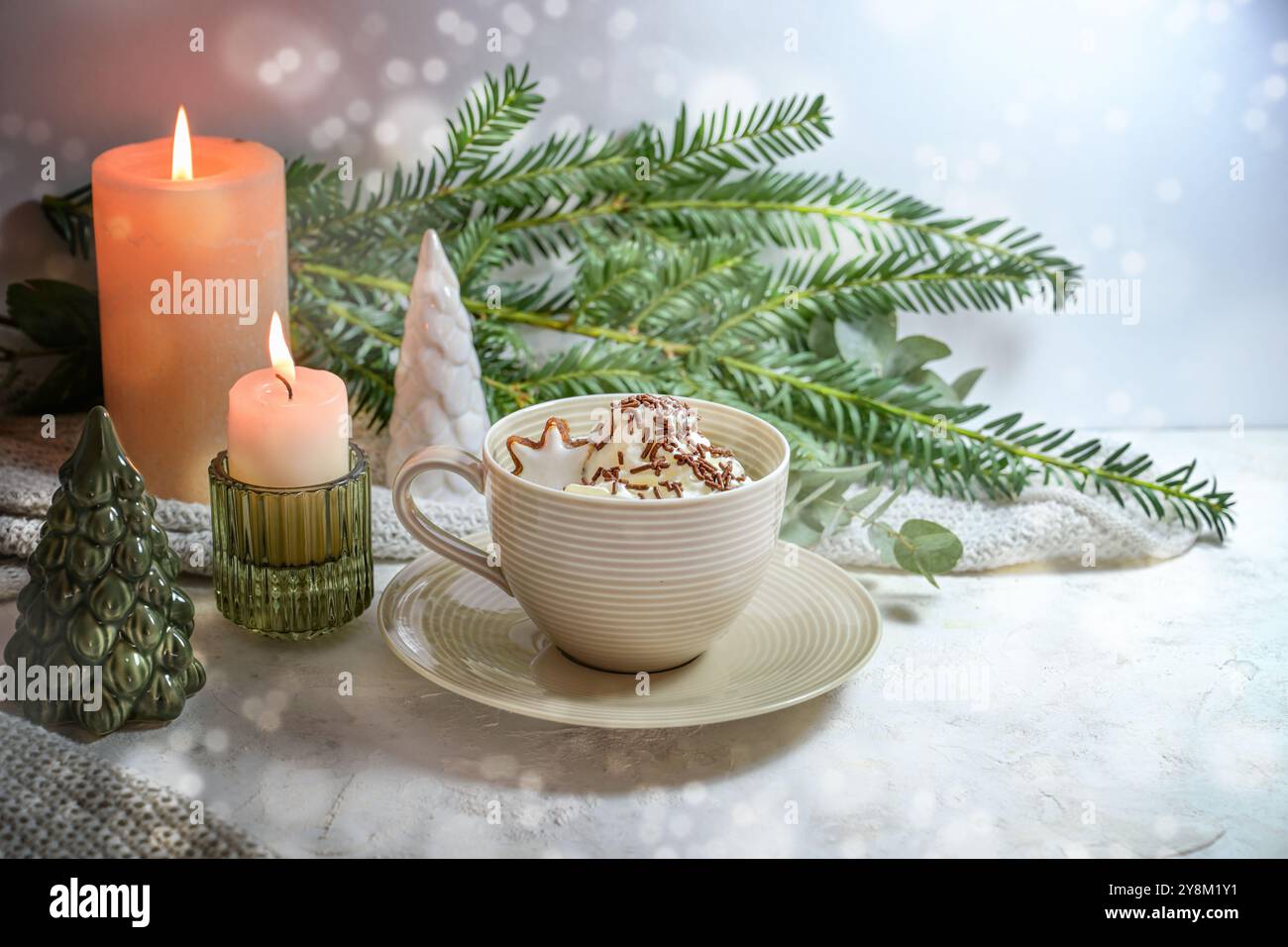 Tasse heiße Schokolade mit Schlagsahne und Zimt-Sternenkeks, Kerzen und Weihnachtsdekoration, süßes warmes Getränk für kalte Feiertage, schneebedeckter Backg Stockfoto