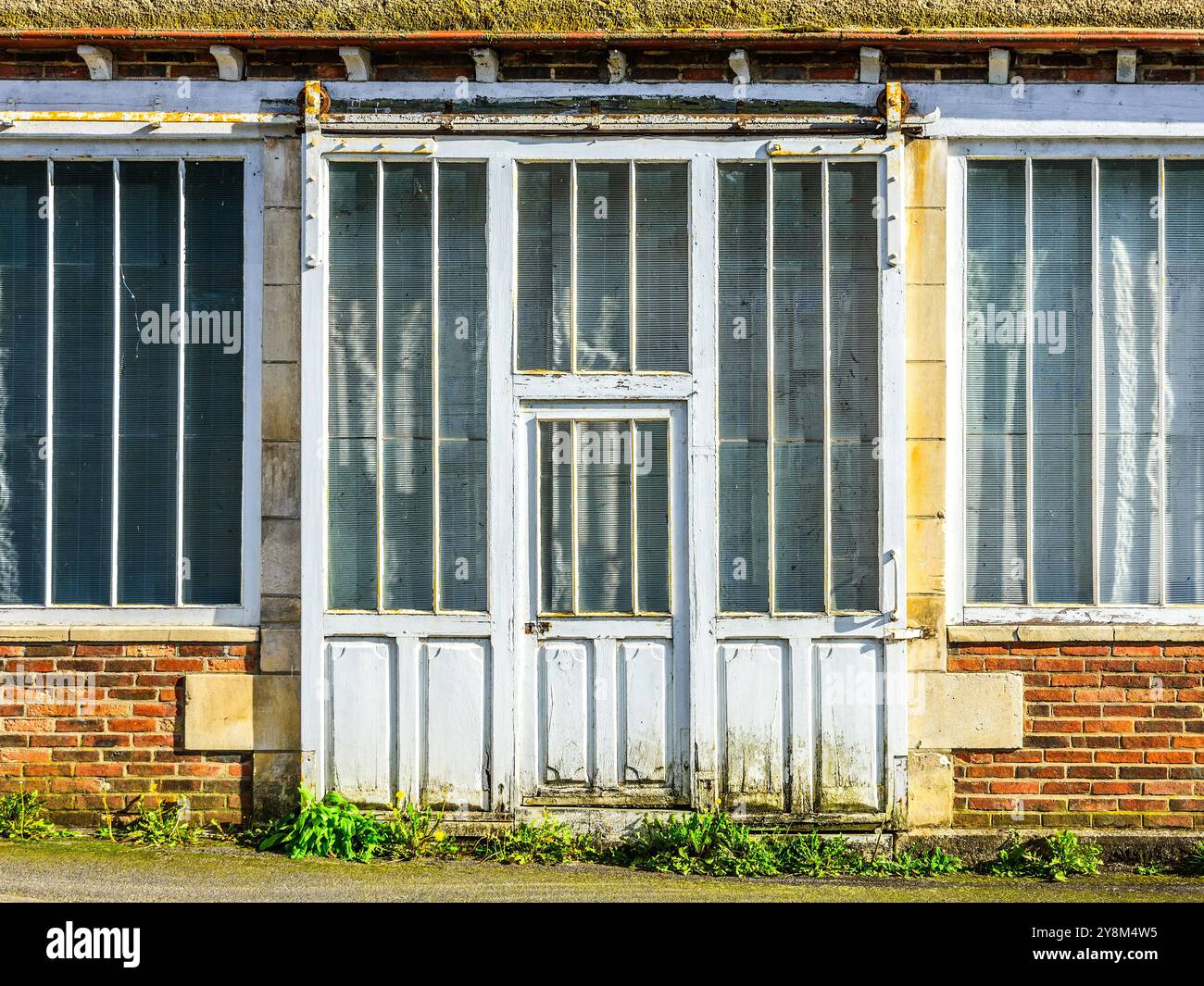 Alte Schiebetür und Fenster vor dem ehemaligen Geschäftsgebäude - La Trimouille, Vienne (86), Frankreich. Stockfoto