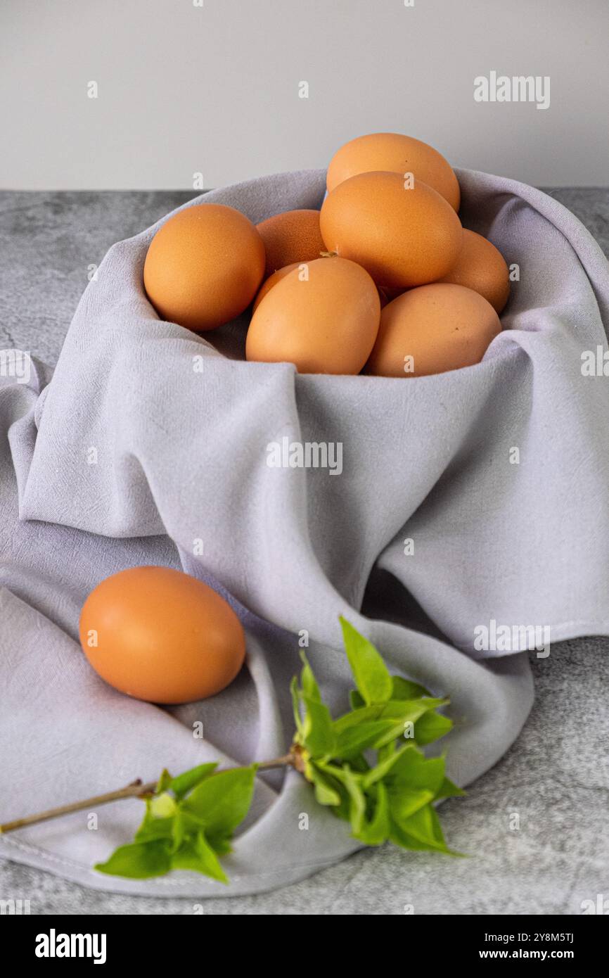 Braune Eier auf grauer Serviette. Vertikales Foto Stockfoto