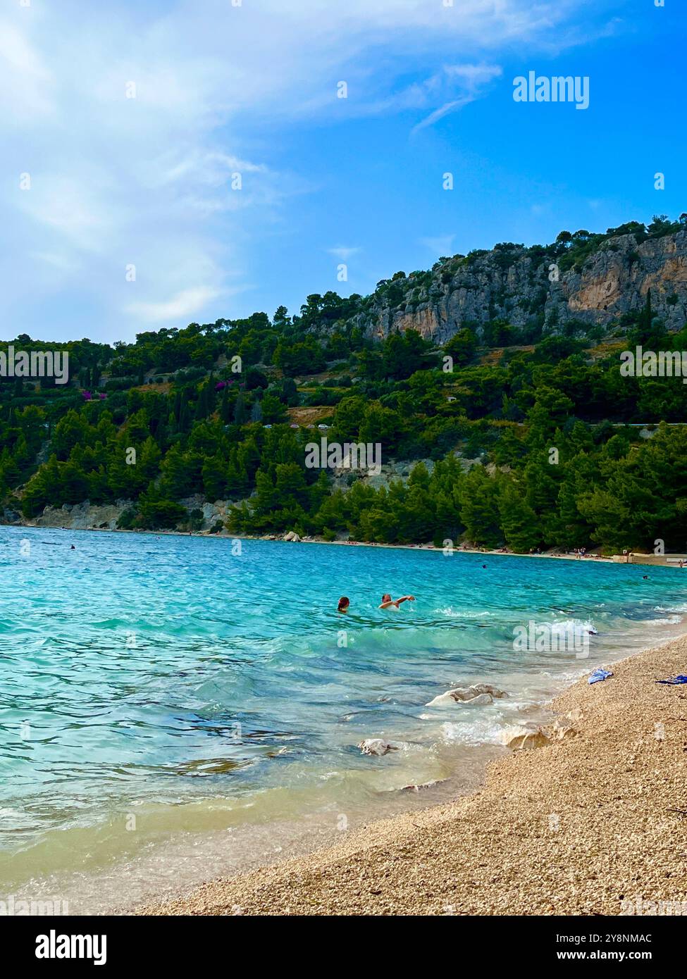 DER STRAND von KAŠJUNI, die sichelförmige Bucht, ist von den baumbedeckten Klippen des Marjan Hill umgeben und das türkisfarbene Wasser ist sauber und klar. - Smartphone-aufgenommenes Stockfoto
