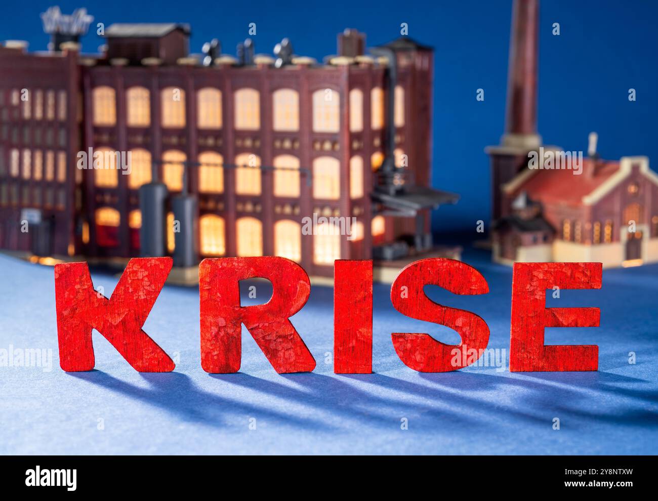 Wirtschaftskrise. Das deutsche Wort Krise vor einer alten Fabrik. Stockfoto