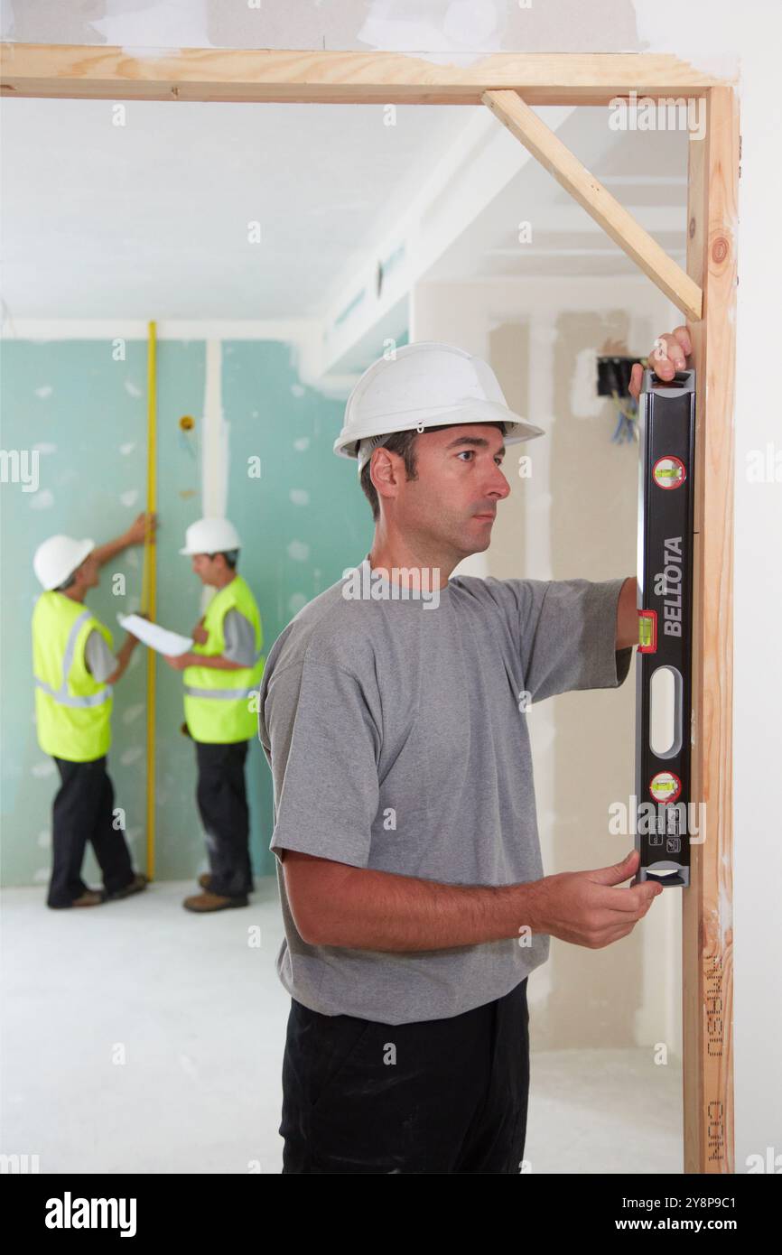 Arbeiter mit Schutzausrüstung, PSA, Nivellierungstür, Gehäusebau, Ebene, Baskenland, Spanien. Stockfoto