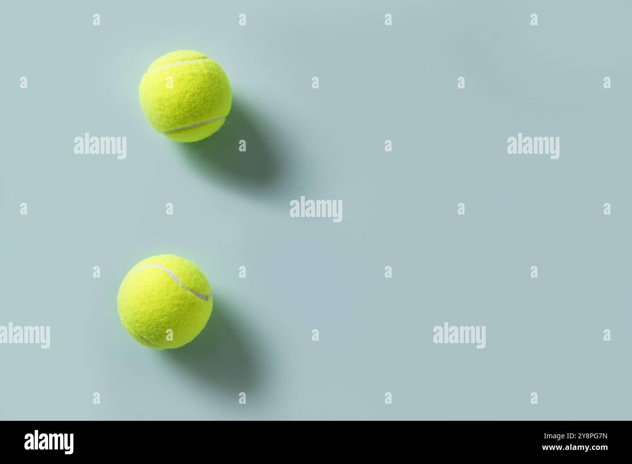 Zwei gelbe Tennisbälle auf blauem Hintergrund. Kopierbereich. Blick von oben. Sommersport. Stockfoto