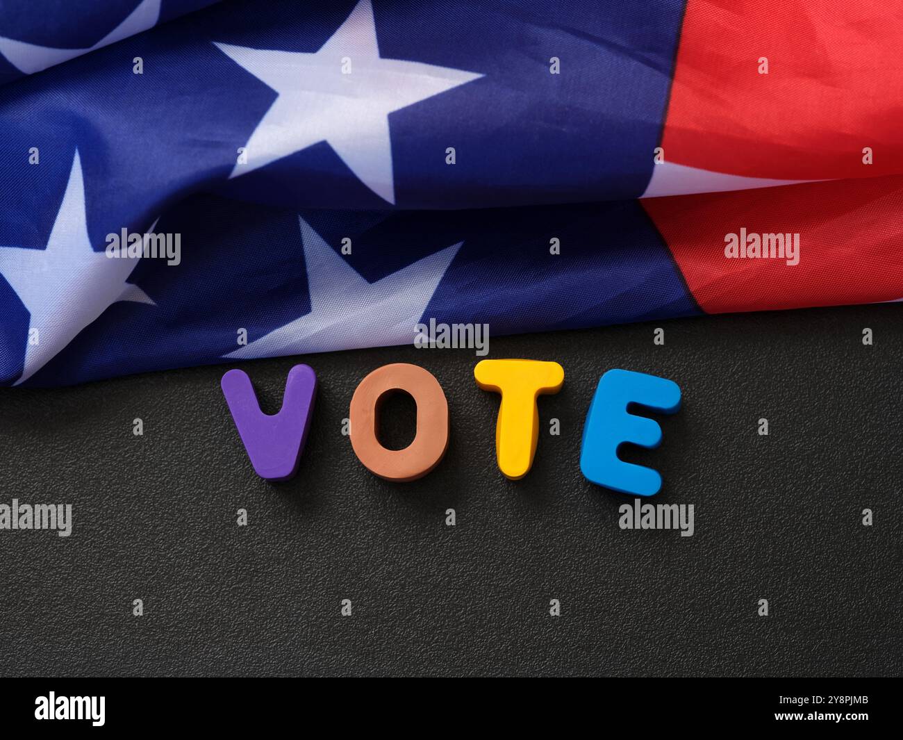 Die Flagge der USA, die auf einer Tafel liegt und die Buchstaben darauf ABSTIMMT. Nahaufnahme. Stockfoto