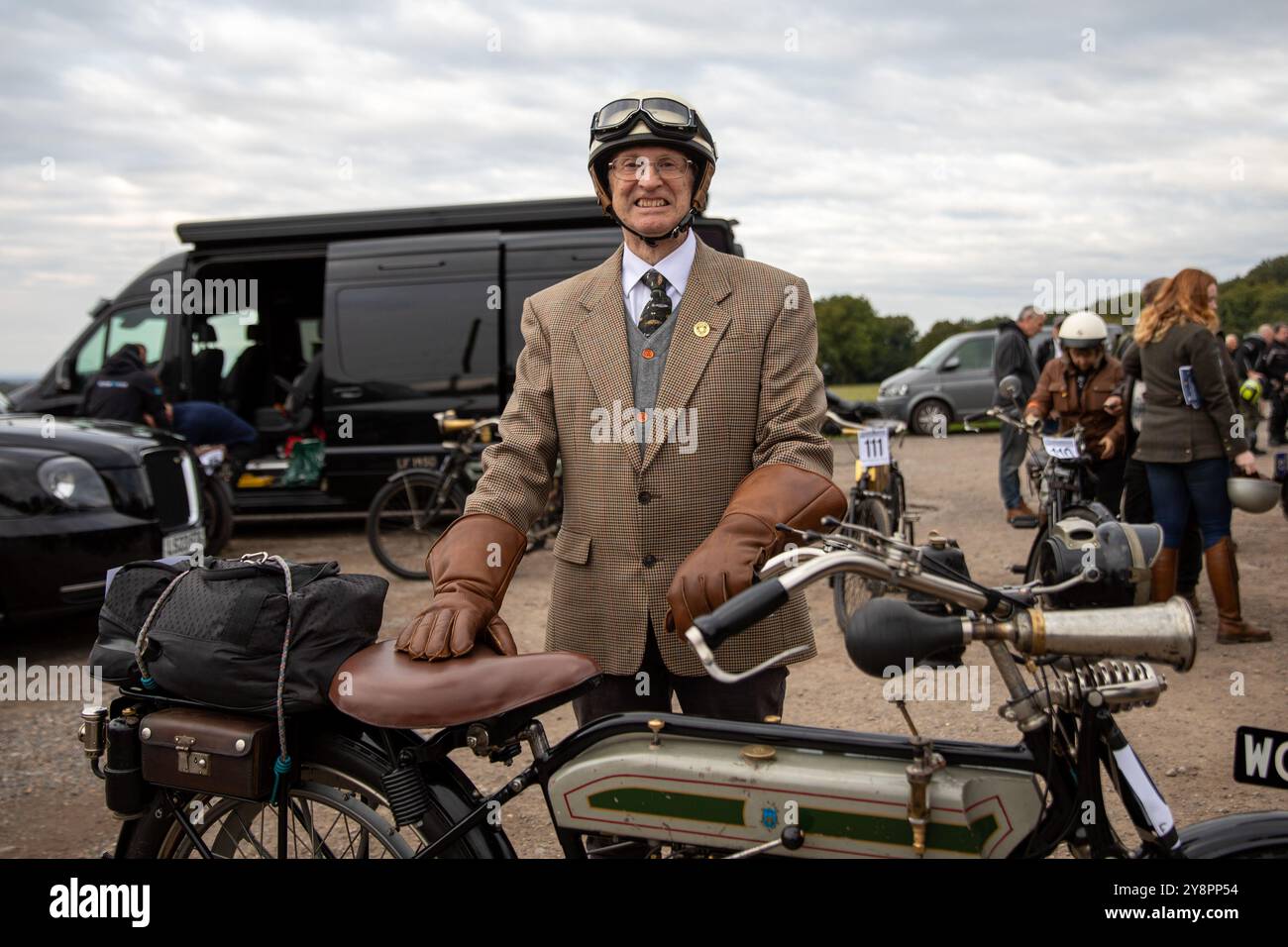 Epsom, Großbritannien. Oktober 2024. Ein englischer Gentleman steht hinter seiner Veteranenmaschine, bevor ein klassischer Motorradlauf beginnt. Hunderte von erfahrenen Motorradfans besuchen den 84. Epsom to Brighton Pioneer Run. Diese jährliche Veranstaltung ist offen für Motorräder, Beiwagen und Dreiräder und alle, die vor 1915 gebaut worden sein sollen. Die Teilnehmer starten von Tattenham Corner Epsom und folgen einer festen 45 km langen Route durch Surrey und East Sussex, die am Brighton City Airport Shoreham endet. Quelle: SOPA Images Limited/Alamy Live News Stockfoto