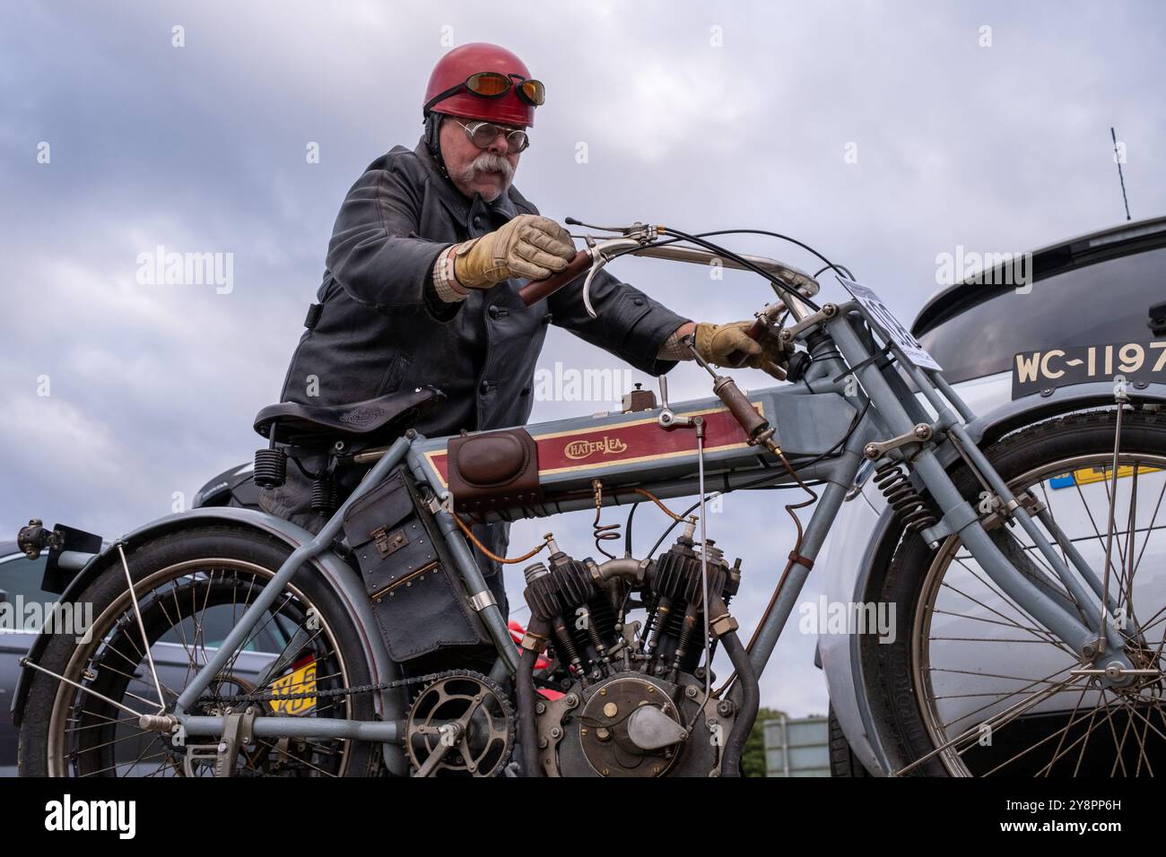 Epsom, Großbritannien. Oktober 2024. Ein erfahrener Motorradliebhaber startet seine Maschine. Hunderte von erfahrenen Motorradfans besuchen den 84. Epsom to Brighton Pioneer Run. Diese jährliche Veranstaltung ist offen für Motorräder, Beiwagen und Dreiräder und alle, die vor 1915 gebaut worden sein sollen. Die Teilnehmer starten von Tattenham Corner Epsom und folgen einer festen 45 km langen Route durch Surrey und East Sussex, die am Brighton City Airport Shoreham endet. Quelle: SOPA Images Limited/Alamy Live News Stockfoto