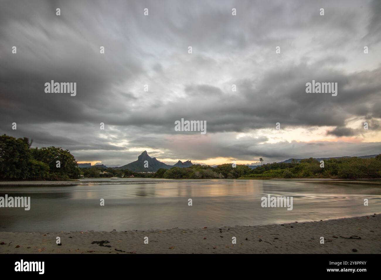 Eine Bucht an einem Fluss. Traumstrand im pastellfarbenen Sonnenuntergang auf einer Urlaubsinsel. Flacher Strand auf der Insel Mauritius, Tamarin Stockfoto
