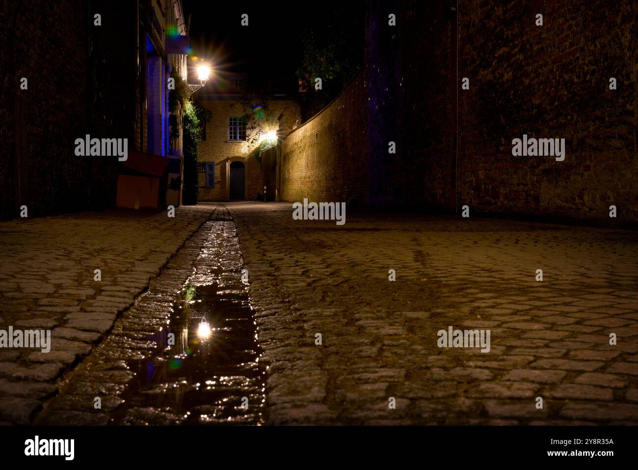 Alte Kopfsteinpflasterallee bei Nacht Brügge. Eine alte enge Gasse bei Nacht in der mittelalterlichen Stadt Brügge, Belgien Stockfoto