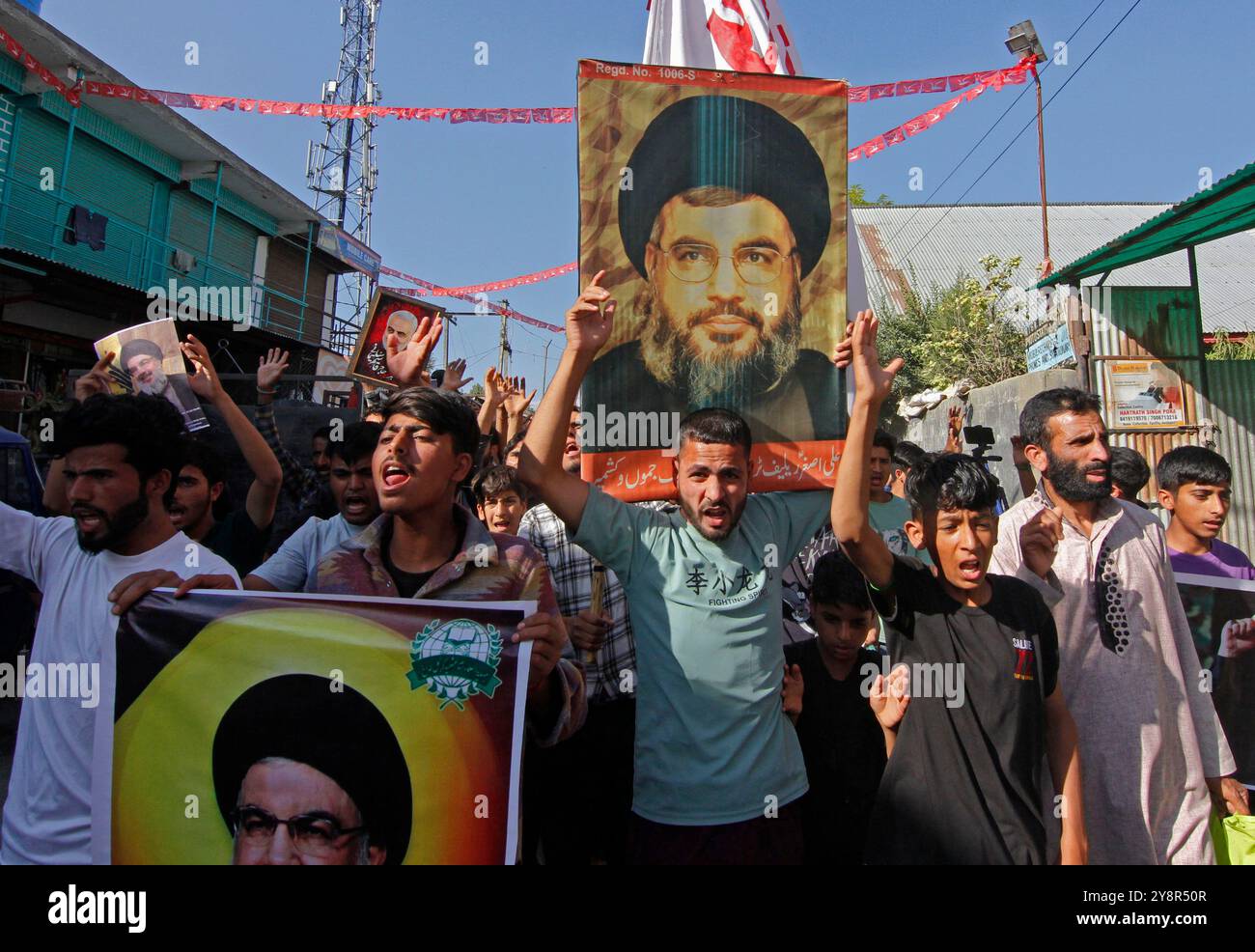 Pattan, Kaschmir, Indien. Oktober 2024. Kaschmiri-schiitische muslime tragen Bilder des Hisbollah-Führers Hassan Nasralla und rufen Anti-Israel-Parolen, während sie an einer Demonstration teilnehmen, um ihre Wut über die Ermordung des Hisbollah-Führers Hassan Nasrallah zu zeigen. Nasrallah wurde in den südlichen Vororten von Beirut, Libanon, durch einen israelischen Luftangriff getötet. Stockfoto