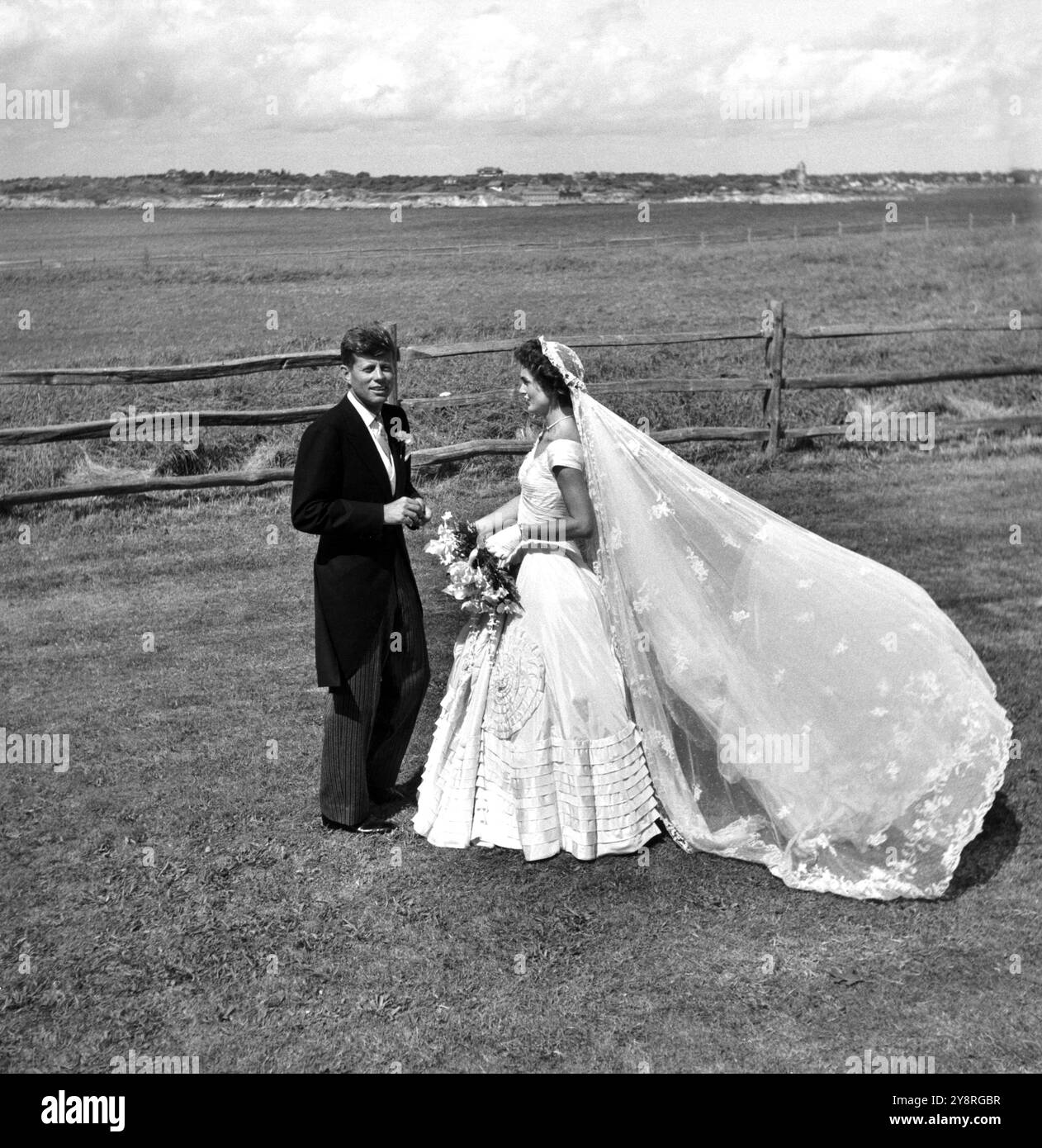 John Kennedy und Jackie Bouvier, in Hochzeitskleidung, stehen draußen. Senator John F. Kennedy und Jacqueline Kennedy an ihrem Hochzeitstag Stockfoto