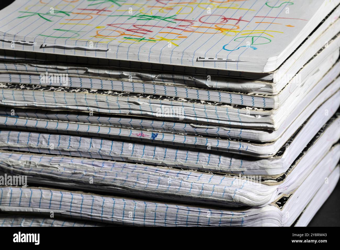 Nahaufnahme des Rückens abgenutzter Notizbücher, die die Alterung und Textur ihrer Seiten betont. Perfekt für Themen im Zusammenhang mit Studium und Schreiben. Stockfoto