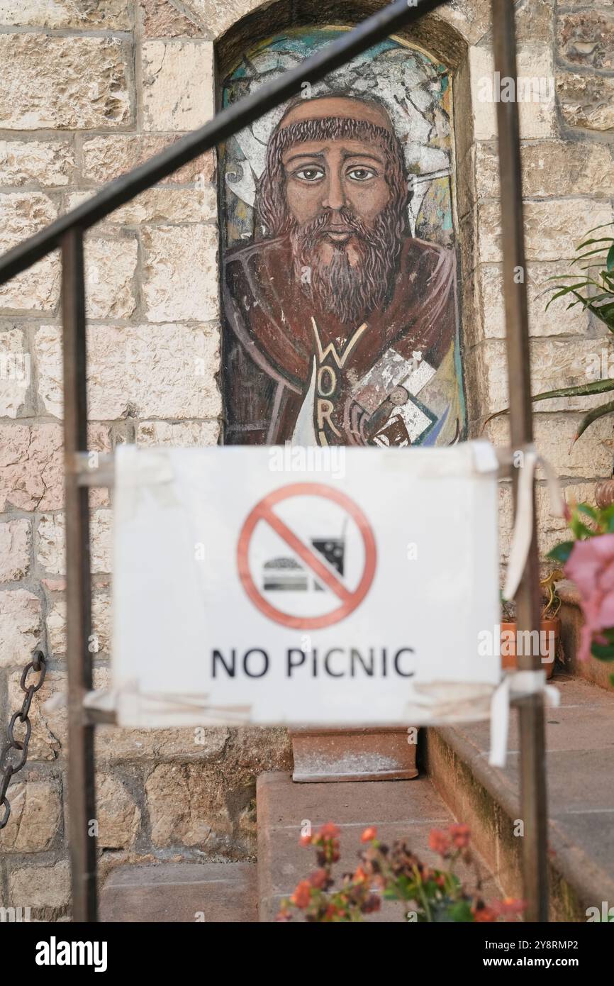 Buntglasfenster des hl. Franziskus von Assisi mit Schild „No Picnic“ in Assisi, Umbrien, Italien Stockfoto