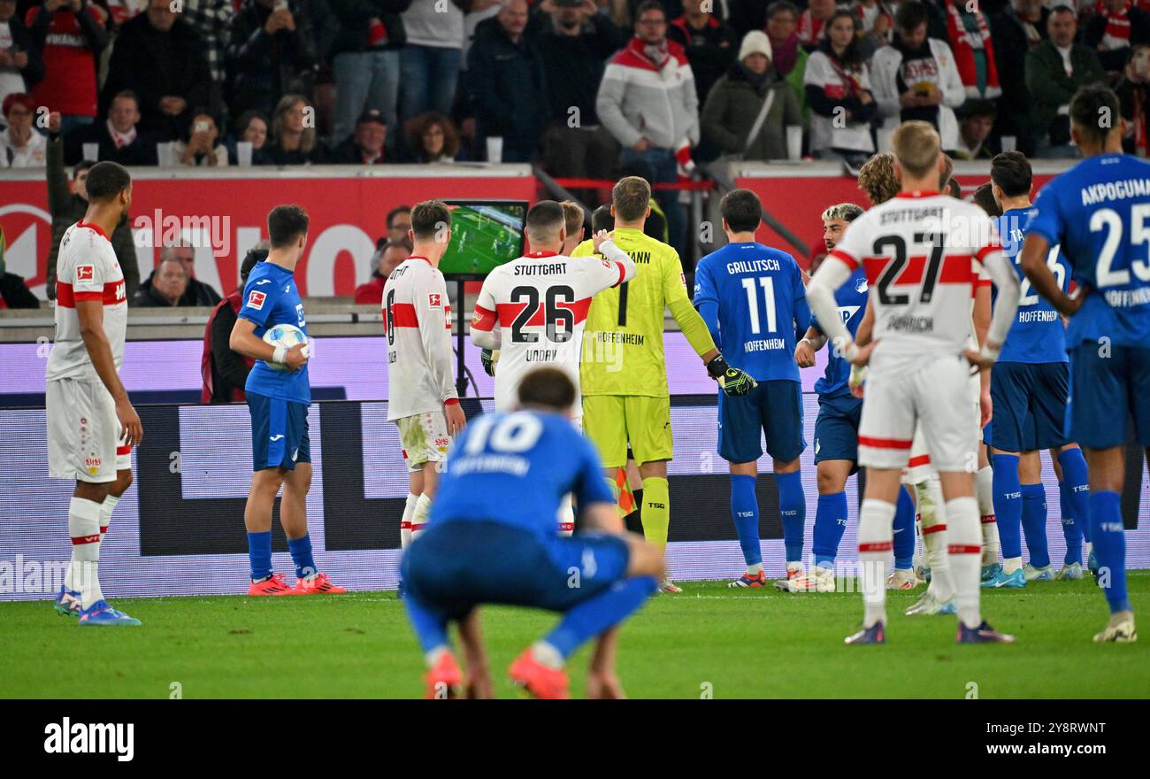 Stuttgart, Deutschland. Oktober 2024. Fußball: Bundesliga, VfB Stuttgart - TSG 1899 Hoffenheim, Spieltag 6, MHPArena. Spieler beider Teams stehen um den VAR-Monitor, während ein Elfmeterschießen in einer Videorezension überprüft wird. Hinweis: Jan-Philipp Strobel/dpa - WICHTIGER HINWEIS: Gemäß den Vorschriften der DFL Deutschen Fußball-Liga und des DFB Deutschen Fußball-Bundes ist es verboten, im Stadion und/oder des Spiels aufgenommene Fotografien in Form von sequenziellen Bildern und/oder videoähnlichen Fotoserien zu verwenden oder zu verwenden./dpa/Alamy Live News Stockfoto