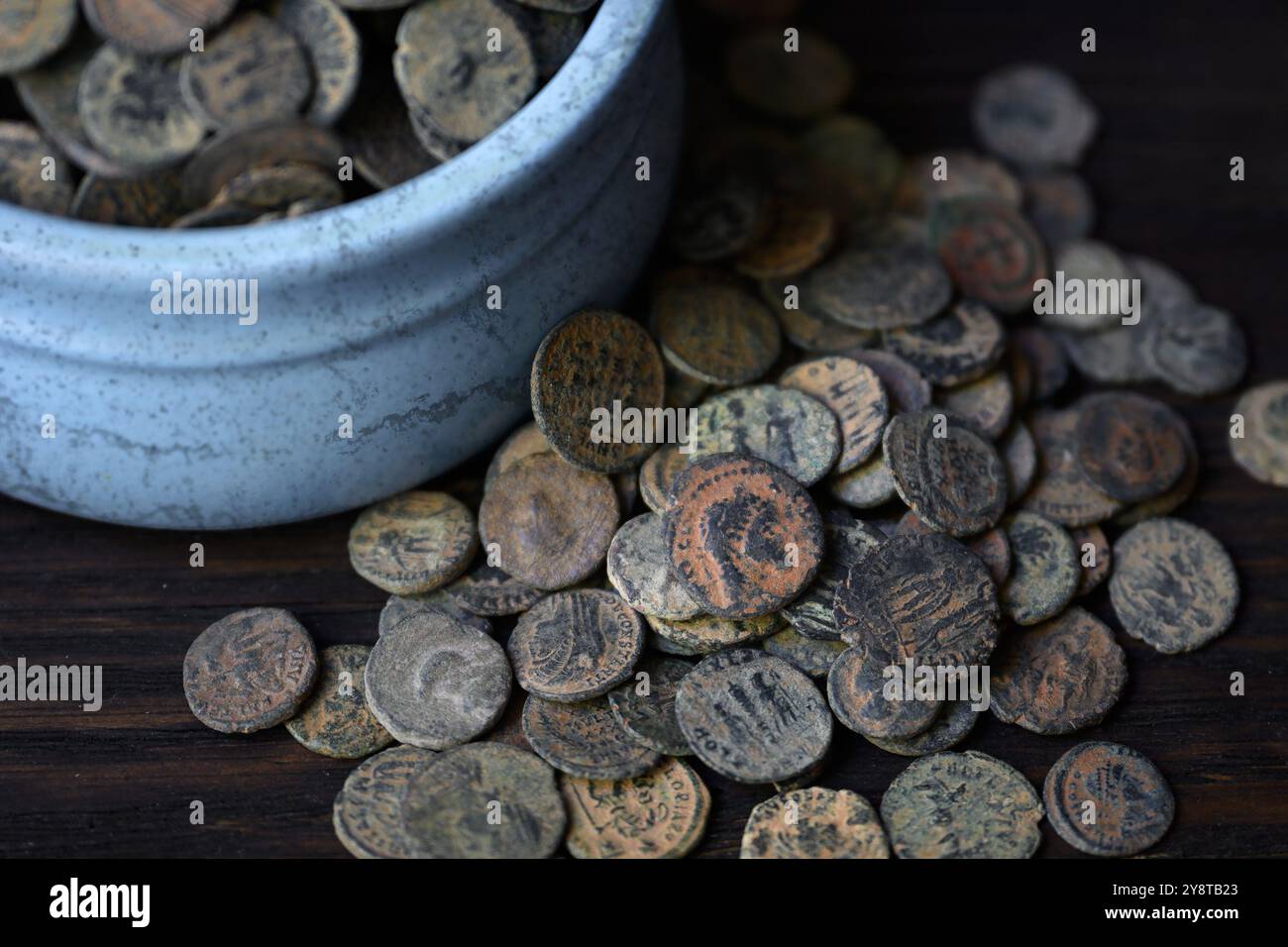 Viele römische Münzen auf einem alten dunklen Holztisch, alte Geldschätze, Vintage-Hintergrund. Konzept von Pile, Antique, Empire, Textur, Zivilisation und Historie Stockfoto