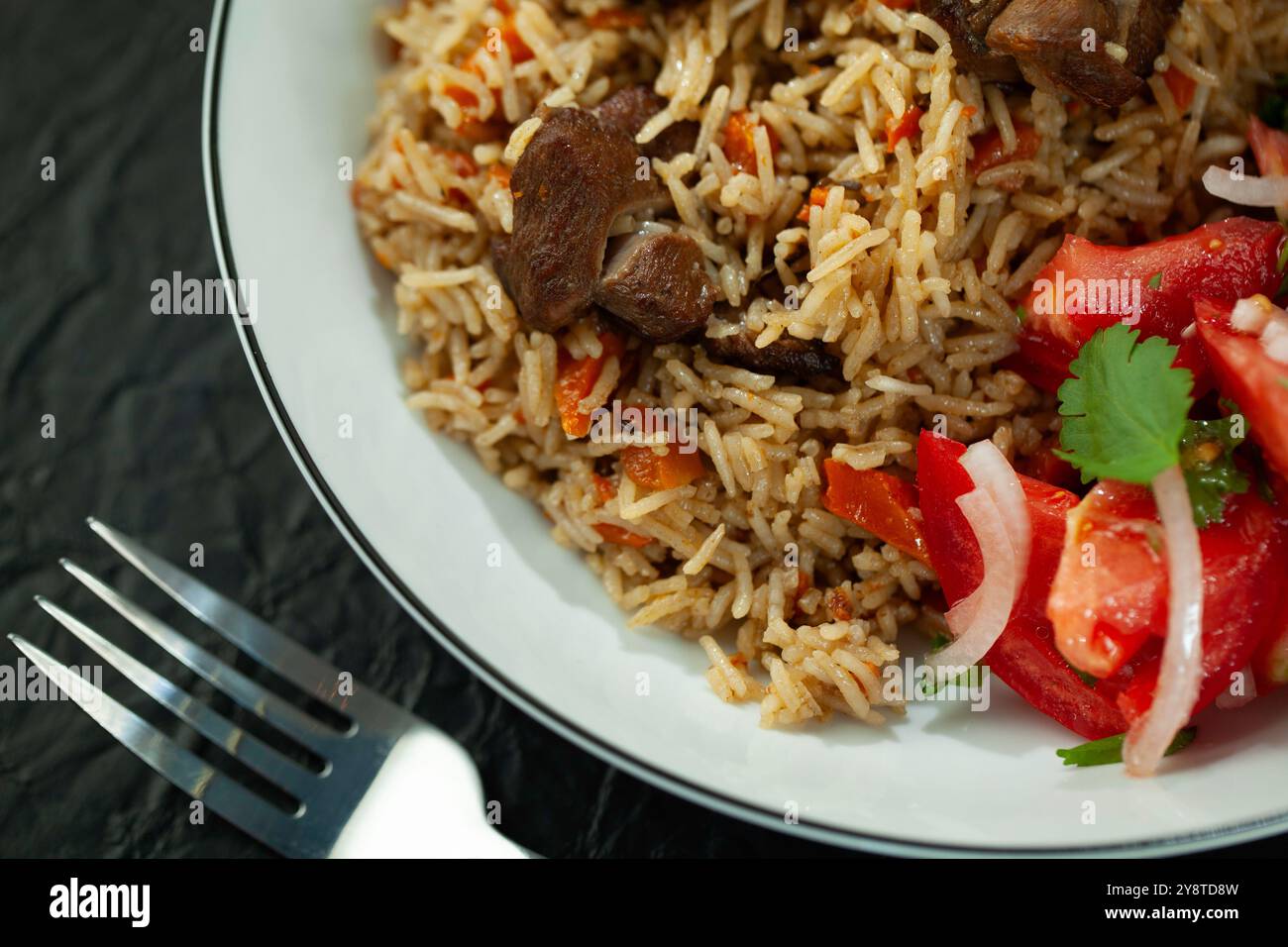 Dampfplatte mit aromatischem Reispilaw mit Fleisch und Gemüse Stockfoto