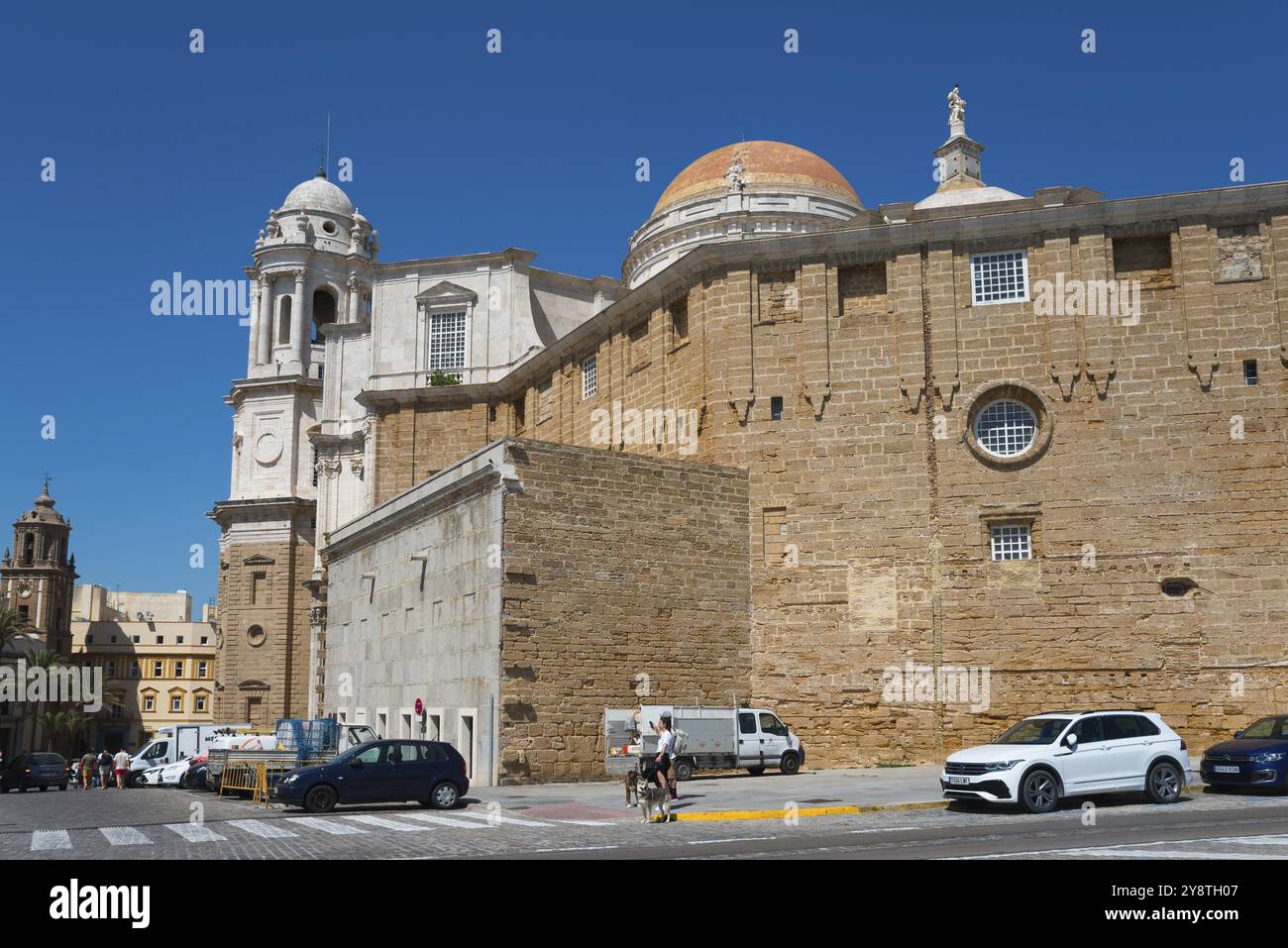 Seitenansicht einer Backsteinkathedrale mit vorbeifahrenden Autos und blauem Himmel, Catedral de Santa Cruz sobre las Aguas, Kathedrale des Heiligen Kreuzes über dem Meer, Alt Stockfoto
