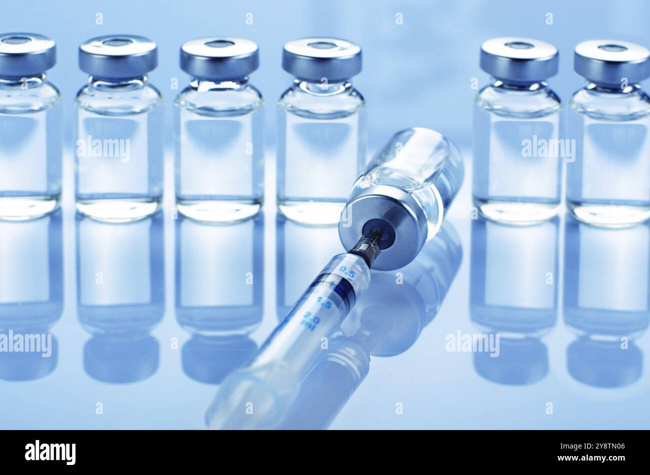 Fläschchen mit flüssigem Medikament als Impfdosis Grippeimpfung zusammen mit Spritze zur Injektionsbehandlung auf dem medizinischen Tisch. Impfungs- oder Impfpflegekonzept b Stockfoto