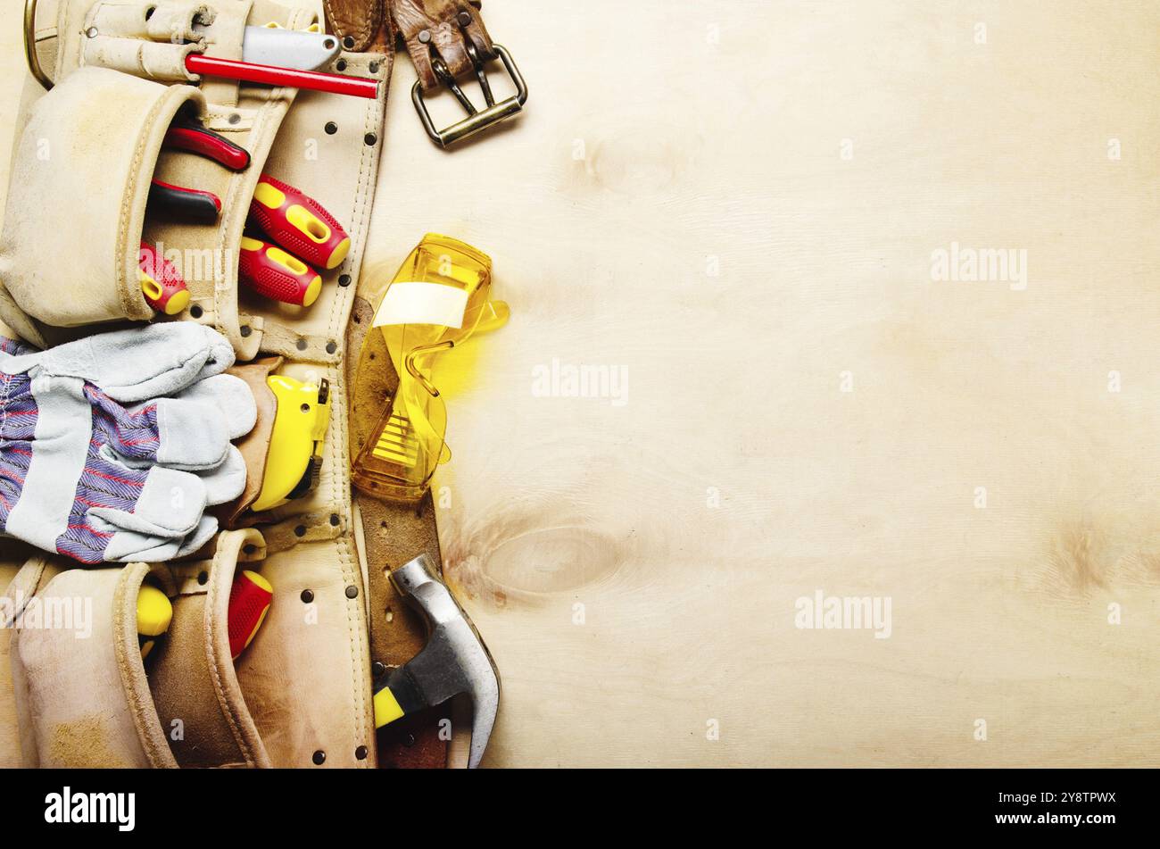 Werkzeuggürtel mit Tischlerwerkzeugen und Schutzverschleiß auf Sperrholz Flachblattansicht des Blatts Stockfoto