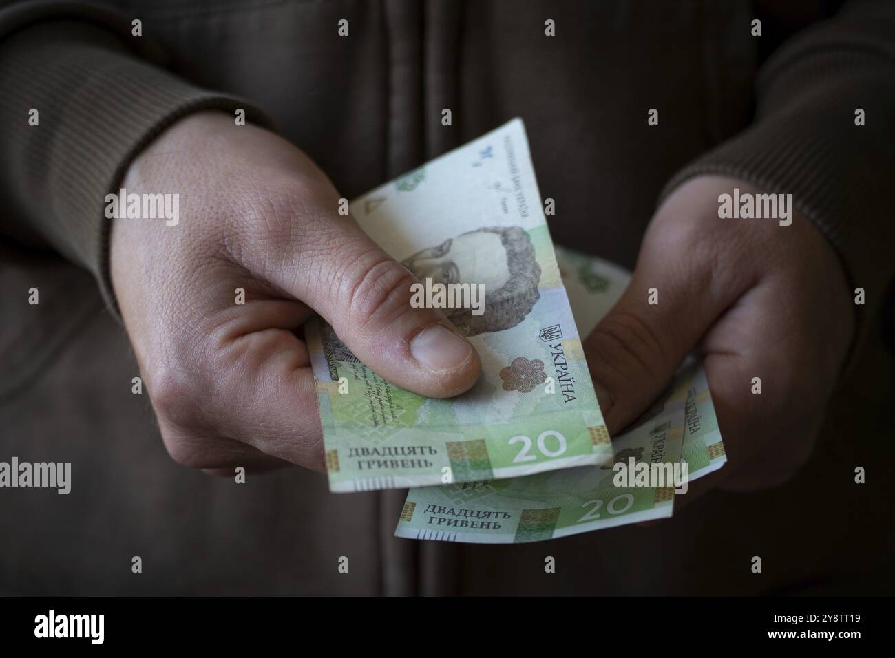 Weißer Mann, der ukrainische Geldscheine aus der Nähe gibt Stockfoto
