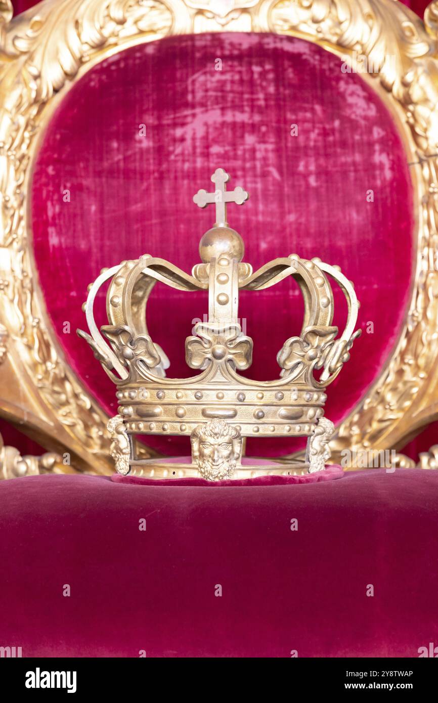 Ancient crown on red velvet. Antique symbol of authority, luxury, monarchy, nobility, success Stockfoto