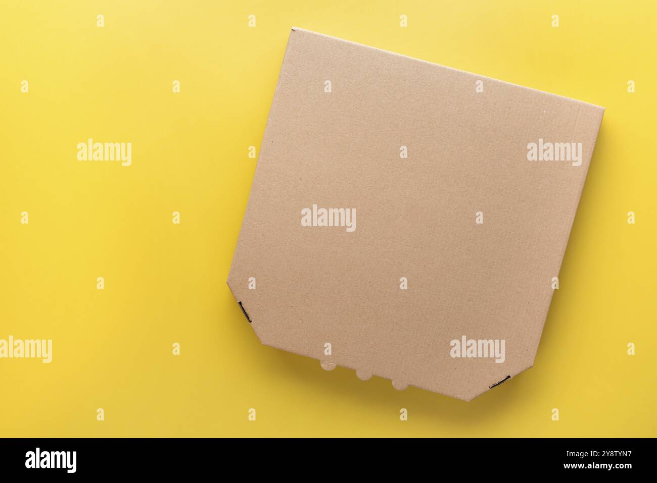 Pizza geschlossener Karton auf einheitlichem gelbem Hintergrund flaches Modell mit leerem Raum Stockfoto