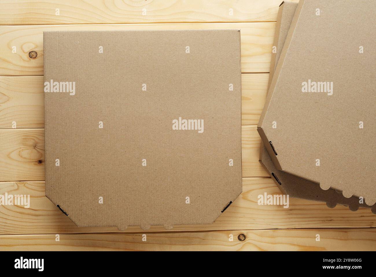 Pizza geschlossene Kartonbox auf natürlichem Holztisch, flaches Modell mit Kopierraum Stockfoto