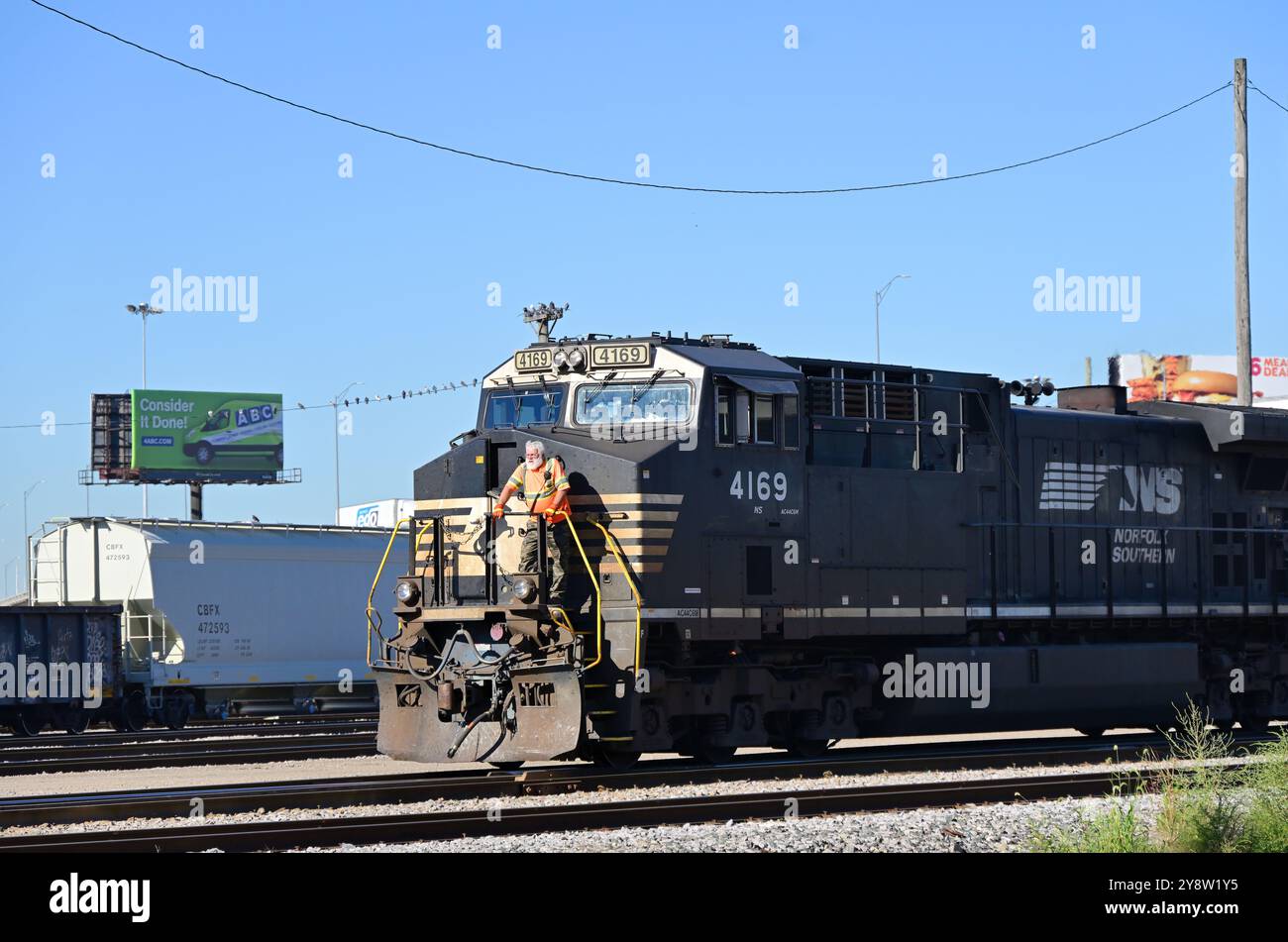 Franklin Park, Illinois, USA. Ein Switchman fährt auf dem Bahnsteig einer führenden Norfolk Southern Railway-Lokomotive, die die letzten Schaltbewegungen pro Stunde durchführt Stockfoto