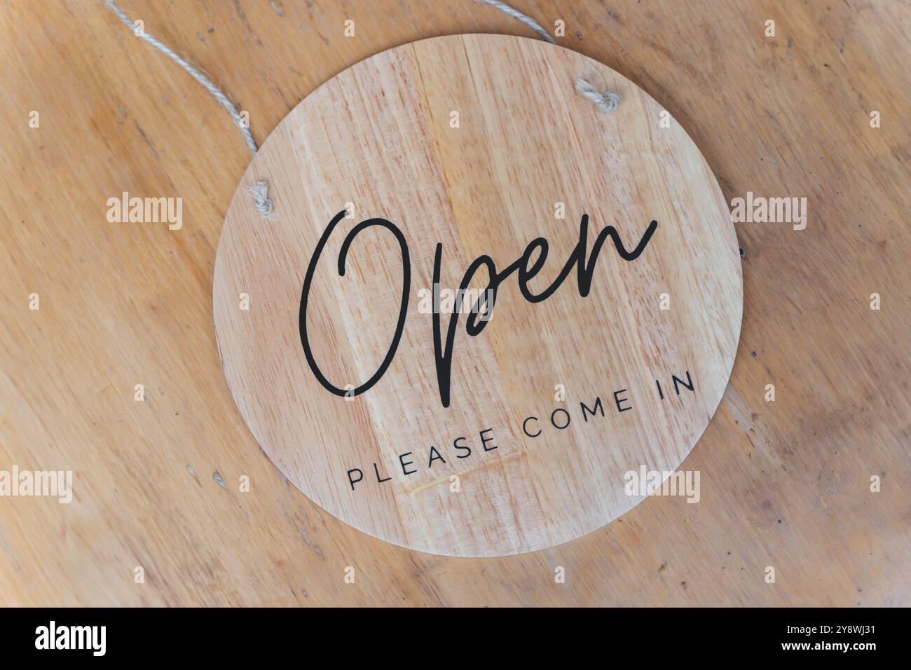 Nahaufnahme eines offenen Ladenschildes vor Holzhintergrund Stockfoto