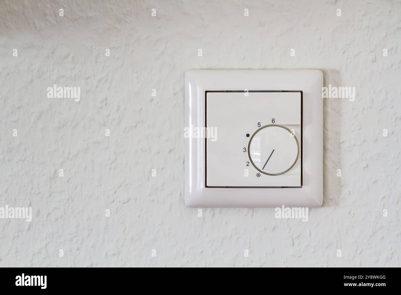 Moderner weißer Thermostat an der weißen Wand Stockfoto