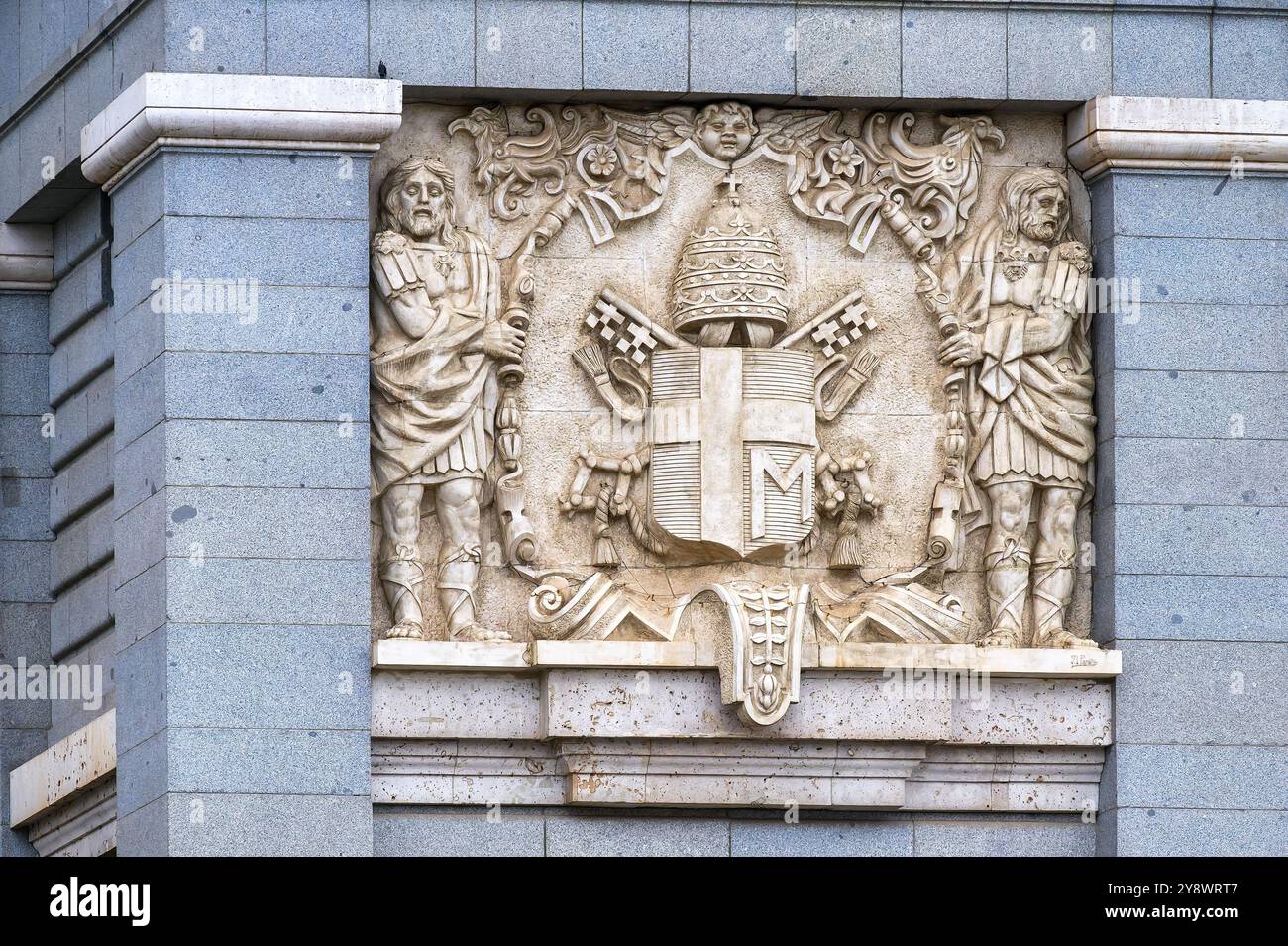 Madrid, Spanien - 26. September 2024: Steinskulptur eines Wappens an der Außenseite der Kathedrale von Almudena. Stockfoto