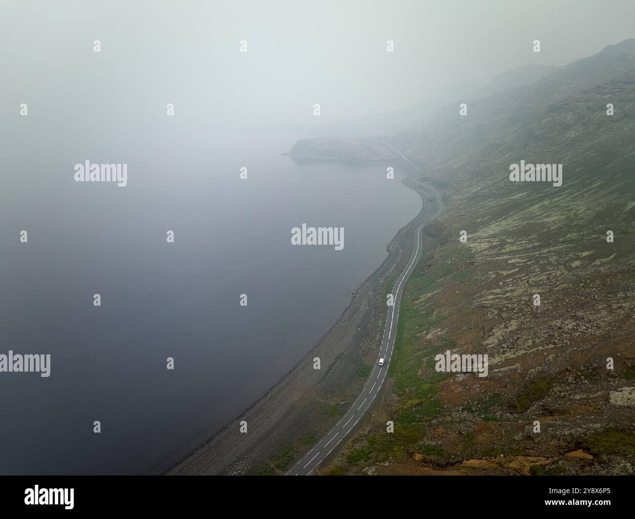 Drohnenansicht der Asphaltstraße mit dem Auto in bergigem Gelände Stockfoto