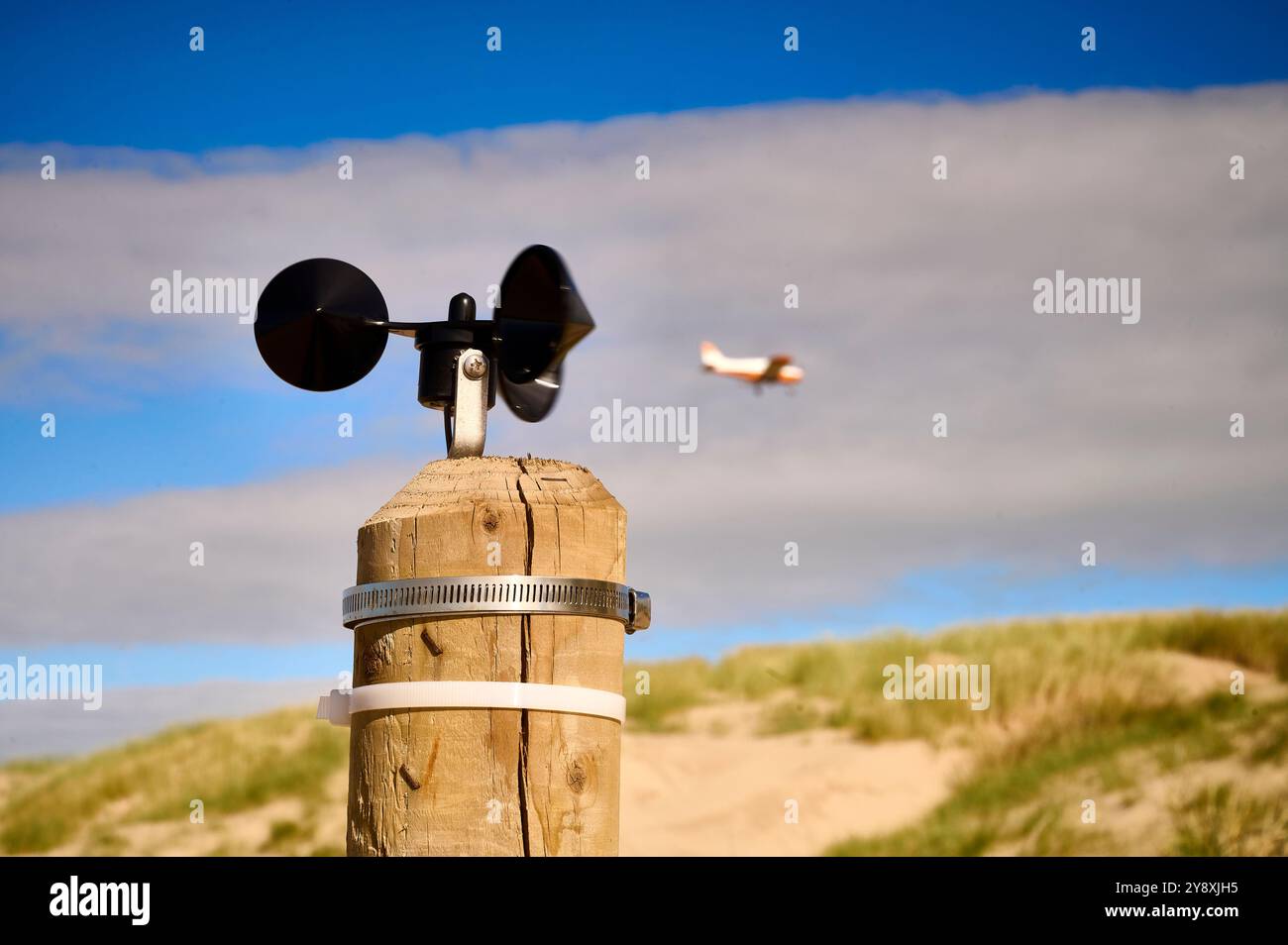 Anemometer auf einem Holzpfosten, der die Windgeschwindigkeit auf Sanddünen misst und wie man vom Wind verwehten Sand dorthin führt, wo er benötigt wird Stockfoto