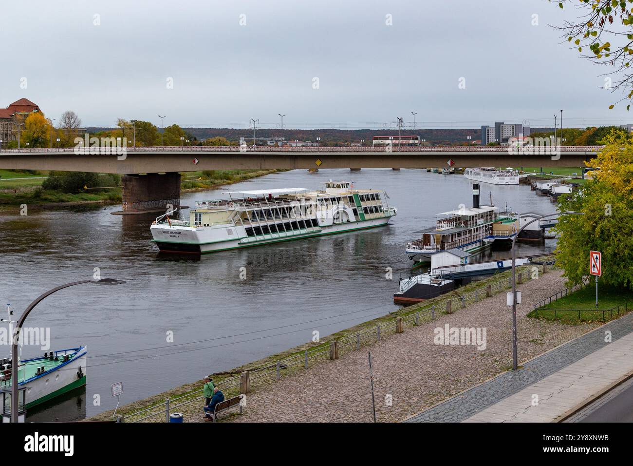 DRESDEN, DEUTSCHLAND - 3. NOVEMBER 2023: Ein Flusskreuzschiff fährt unter der Neuen Karolabridge auf der Elbe vorbei. Stockfoto DRESDEN, DEUTSCHLAND - 3. NOVEMBER 2023: Ein Flusskreuzschiff fährt unter der Neuen Karolabridge auf der Elbe vorbei. Stockfoto