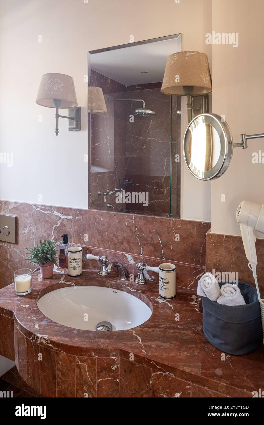 Spiegel über Waschbecken mit braunem Marmor in spanischer Villa auf Mallorca. Stockfoto