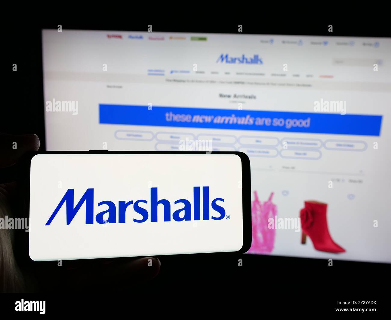 Person mit Smartphone und Logo der US-Kaufhausfirma Marshalls Inc. Auf dem Bildschirm vor der Website. Schwerpunkt auf dem Display des Telefons. Stockfoto