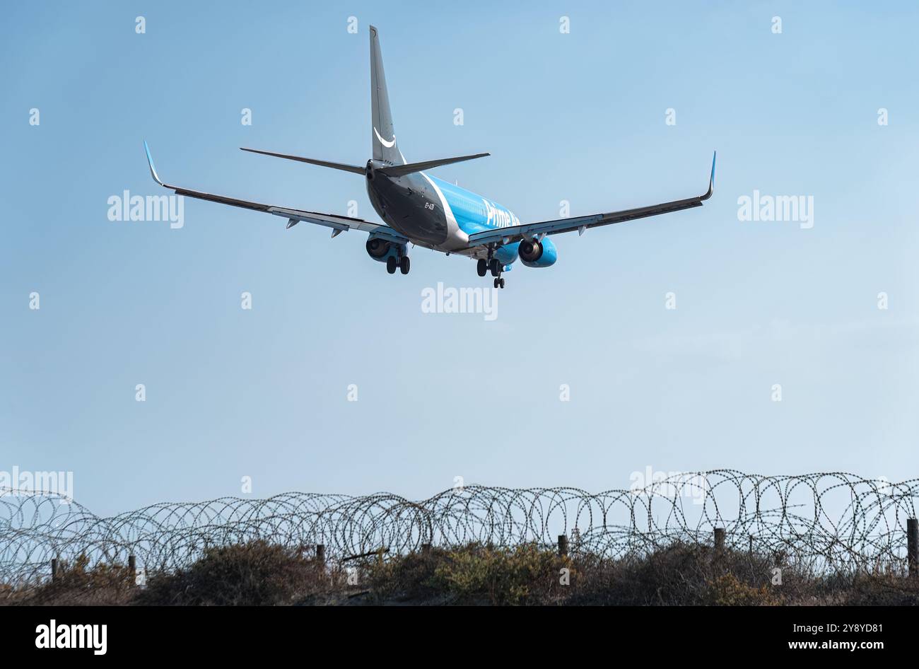Larnaca, Zypern - 29. Juni 2024: Amazon Prime Air-Frachtflugzeug nähert sich zur Landung und fliegt über einen Stacheldrahtzaun am Flughafen Larnaca Stockfoto