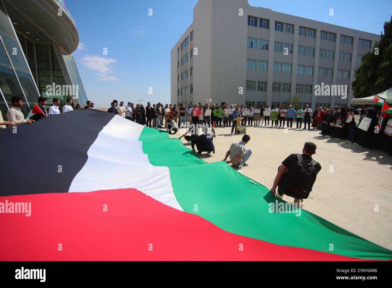 Gaziantep, Turkiye. Oktober 2024. Eine große palästinensische Flagge wird auf dem Campus der Universität für Islamische Wissenschaften und Technologie Gaziantep während eines Protestes zum Gedenken an den Krieg Israels im Gazastreifen angebracht. Die israelische Militäroffensive begann am selben Tag des Angriffs der Hamas auf Israel am 7. Oktober. Quelle: IMAGESLIVE/Alamy Live News Stockfoto