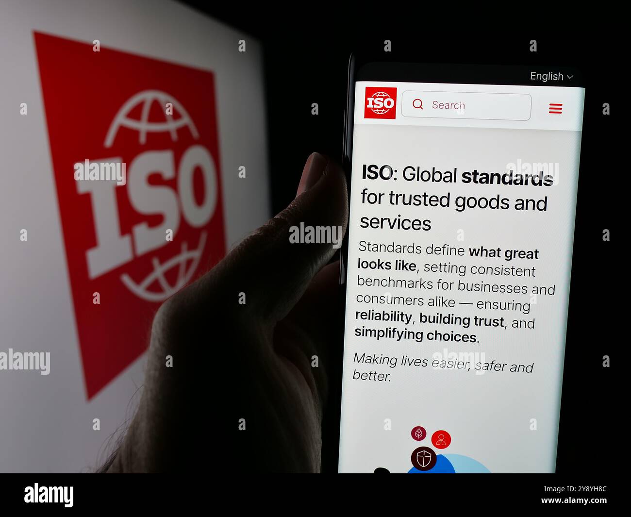 Person, die das Telefon hält, mit der Webseite der Internationalen Organisation für Normung (ISO) auf dem Bildschirm mit Logo. Konzentrieren Sie sich auf die Mitte des Telefondisplays. Stockfoto