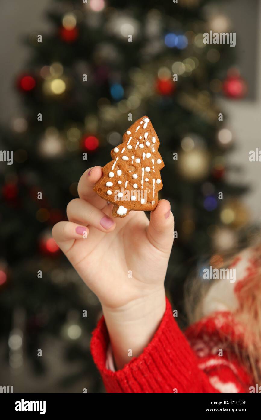 Nahaufnahme von Kinderhand, die Weihnachtskuchenkeks hält Stockfoto