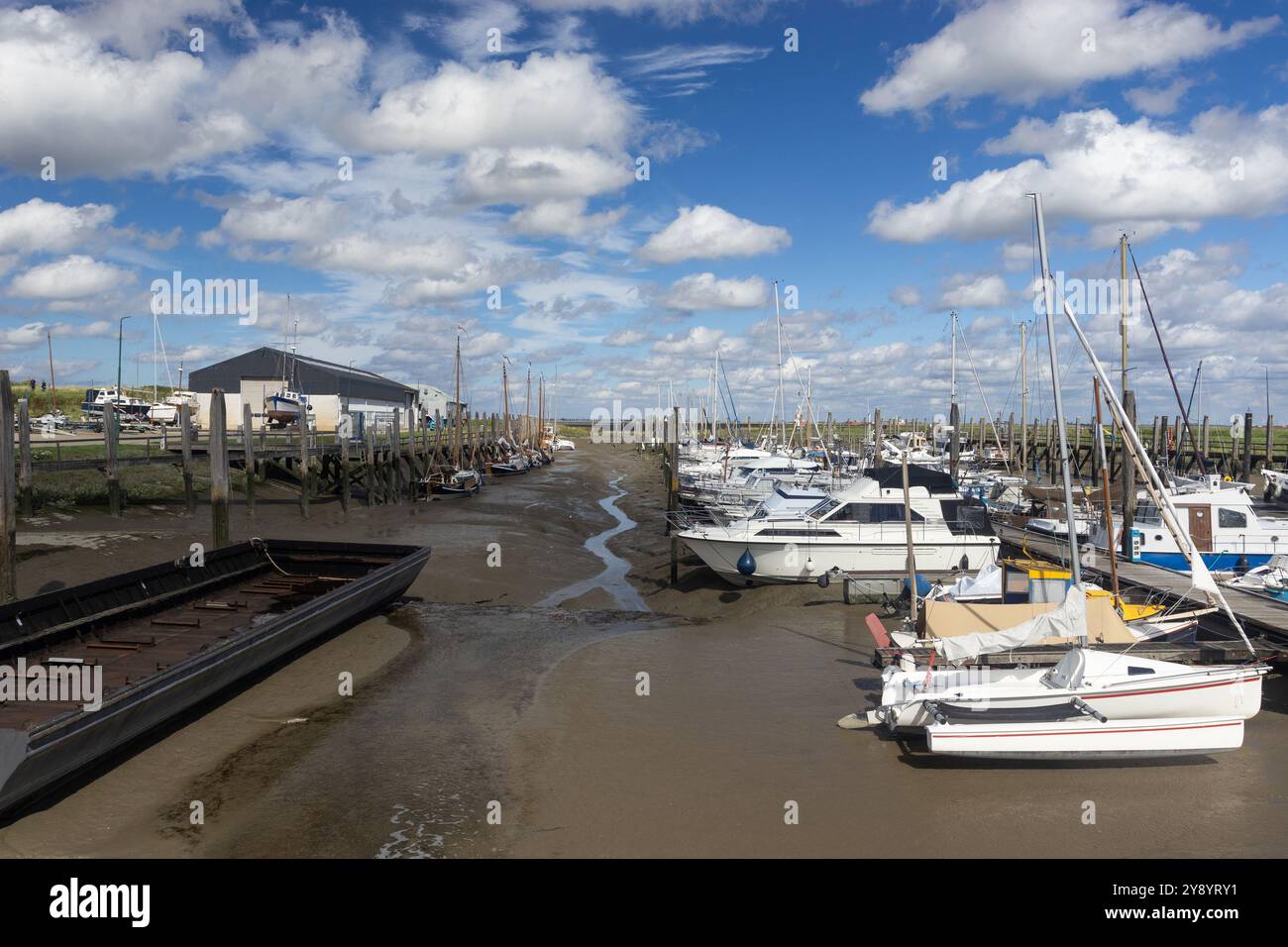 Der Yachthafen bei Paal in Graauw, Zeeland in den Niederlanden. Ebbe mit Booten an einem Sommertag. Stockfoto