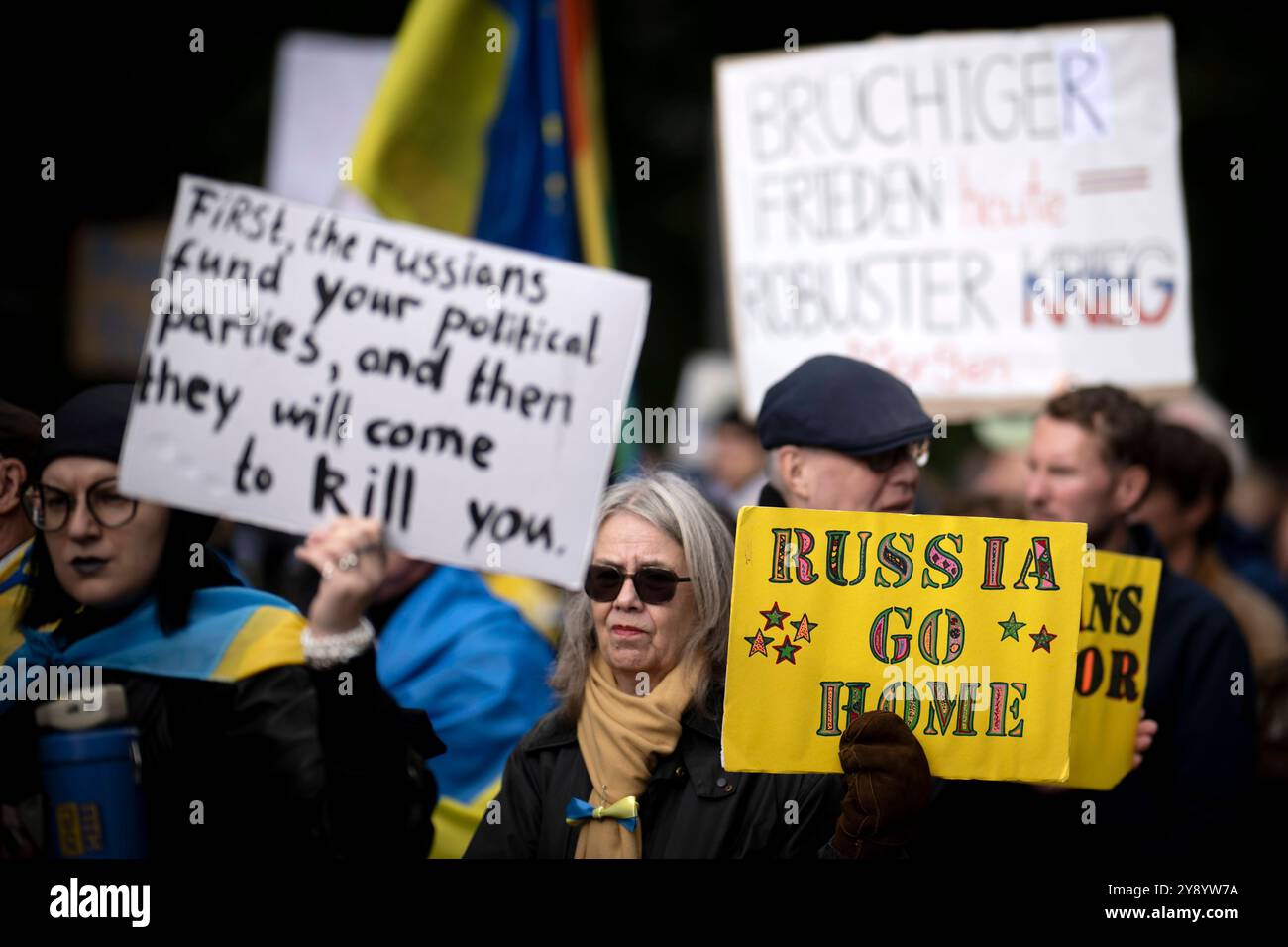 Gegenprotest Friedensdemo DEU, Deutschland, Deutschland, Berlin, 03.10.2024 Gegenprotest von Mitgliedern der Gemeinde aus der Ukraine und ukrainesolidarische Organisation Vitsche mit Plakat Russia Go Home gegen die Russlandfreundliche Demonstration der deutschen Friedensbewegung unter dem Motto Nein zu Kriegen und Hochruestung die Waffen nieder Ja zu Frieden und soziale Friedenspolitik vor der Siegessaeule in Berlin Deutschland. Der Protest verschiedene Initiativen und Parteien wie Buendnis Bündnis BSW Sahra Wagenknecht , SPD, die linke , Gewerkschaften etc. Fordert einen Waffenstillstand in Gaza Stockfoto