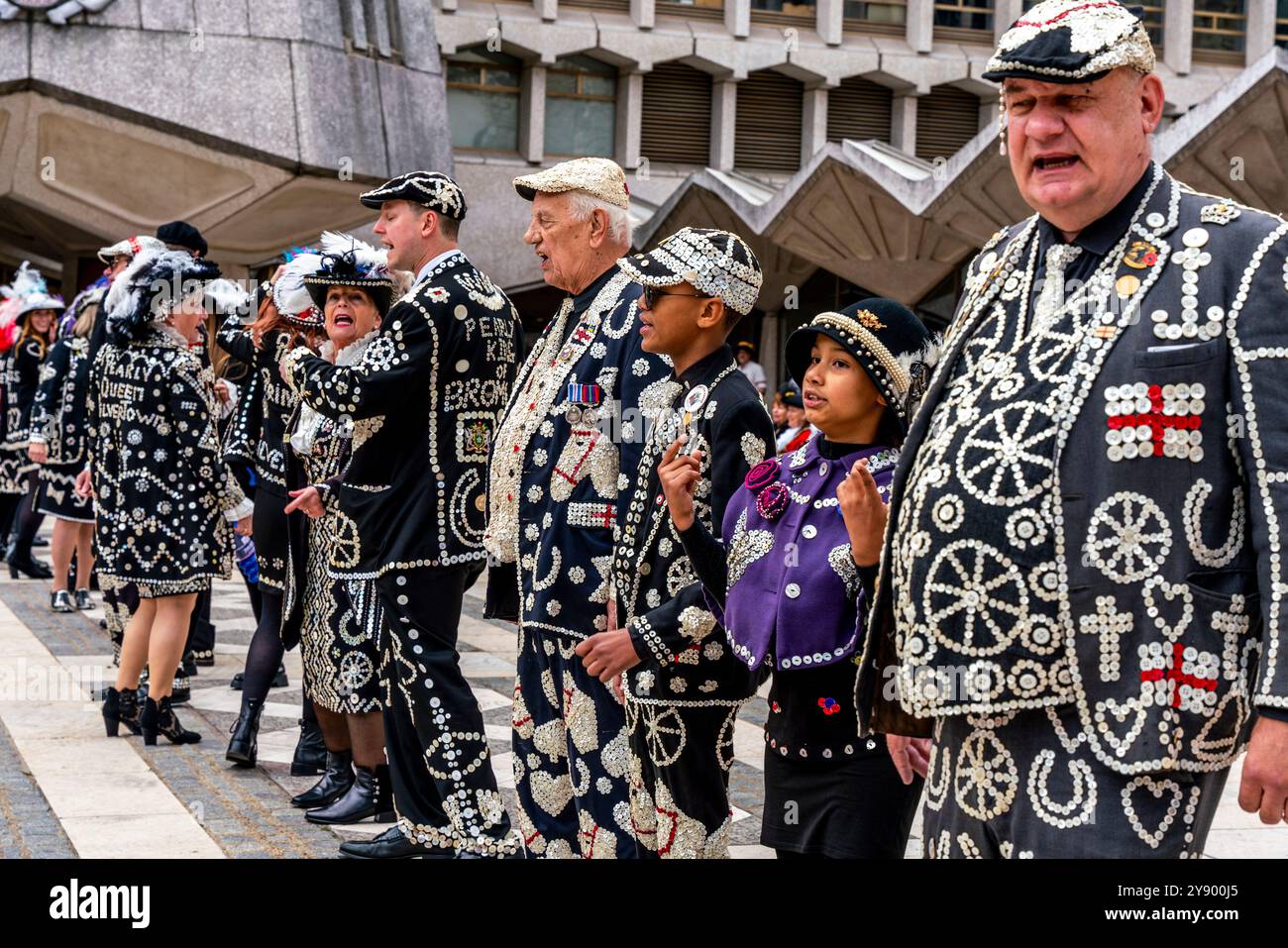 Eine Gruppe von Pearlies singt traditionelle Lieder beim jährlichen Pearly Kings and Queens Costermongers Harvest Festival, The Guildhall Yard, London, Großbritannien. Stockfoto